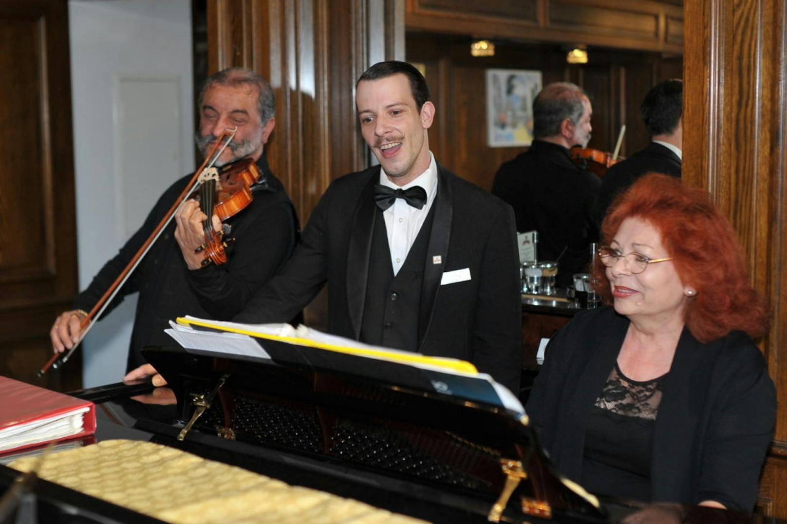 Geiger Ernest und Pianistin Dida begleiten den singenden Kellner.