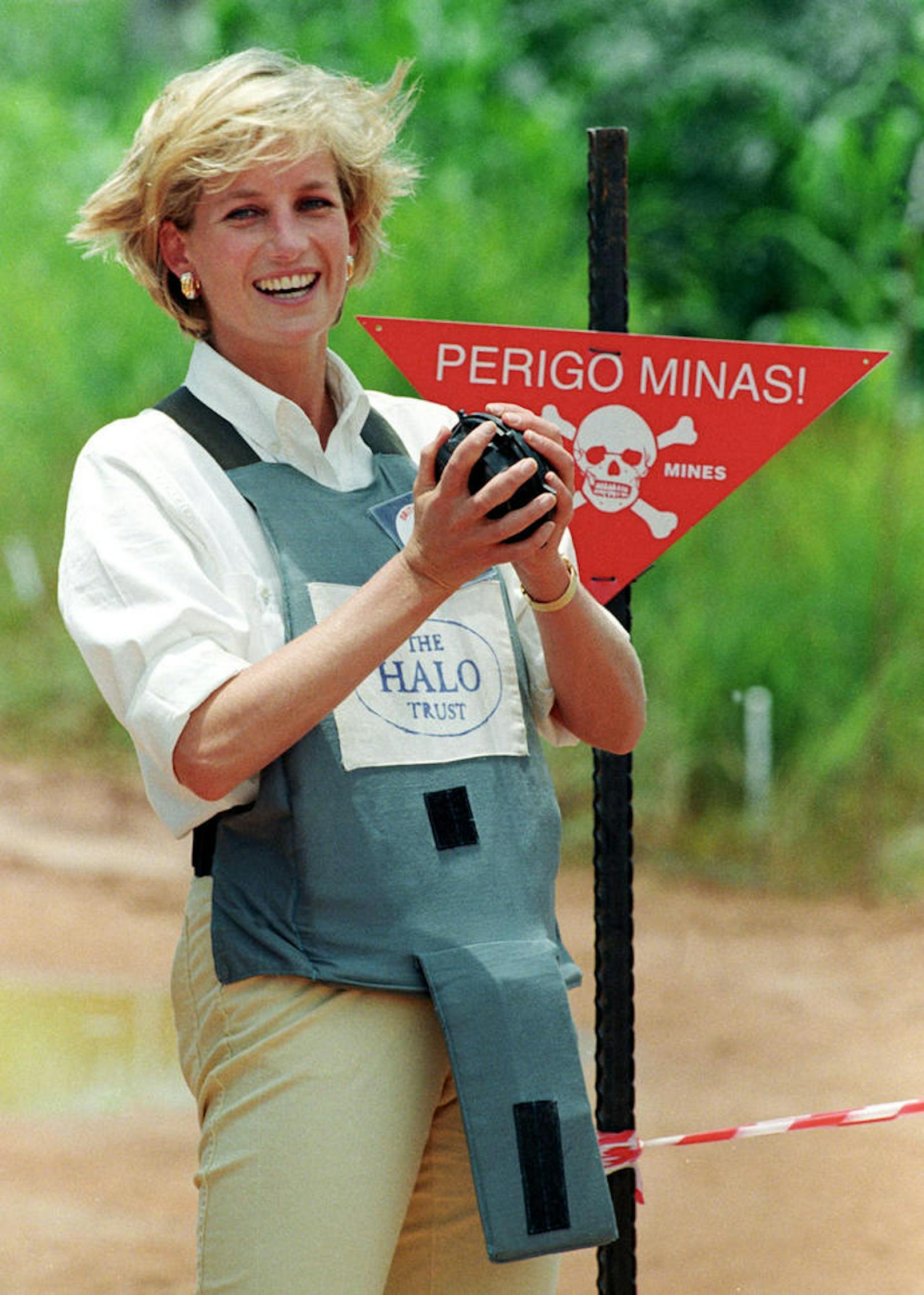Diana hält eine Miene bei einem Besuch auf einem Landmienenfeld in Angola, 1997.