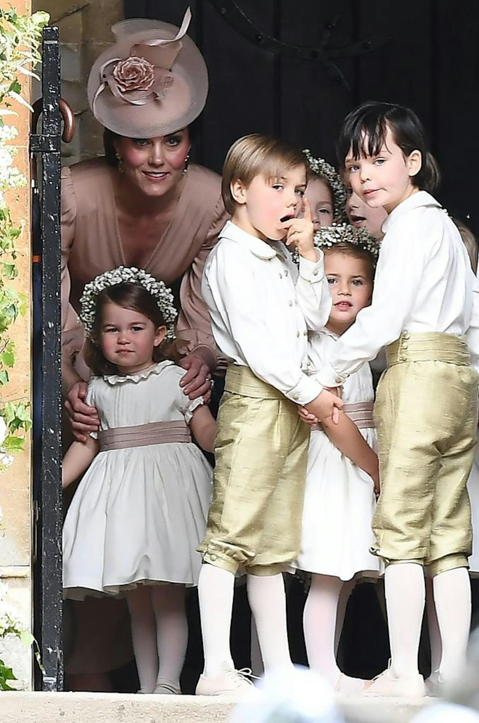 Herzogin Catherine beobachtet mit Töchterchen Prinzessin Charlotte und anderen Blumenmädchen und Pageboys die Ankunft der Braut.