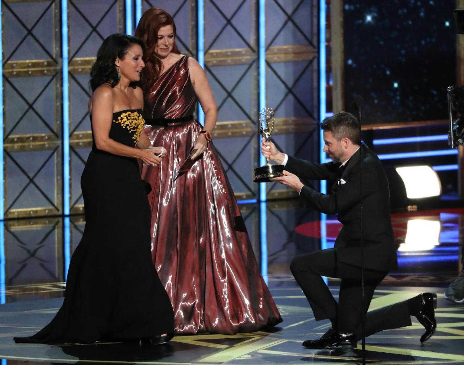 Chris Hardwick (daneben Debra Messing( sinkt vor Julia Louis Dreyfus auf die Knie. Sie bekommt den Emmy für die Beste Hauptdarstellerin in einer Comedy Serie für  "Veep"
