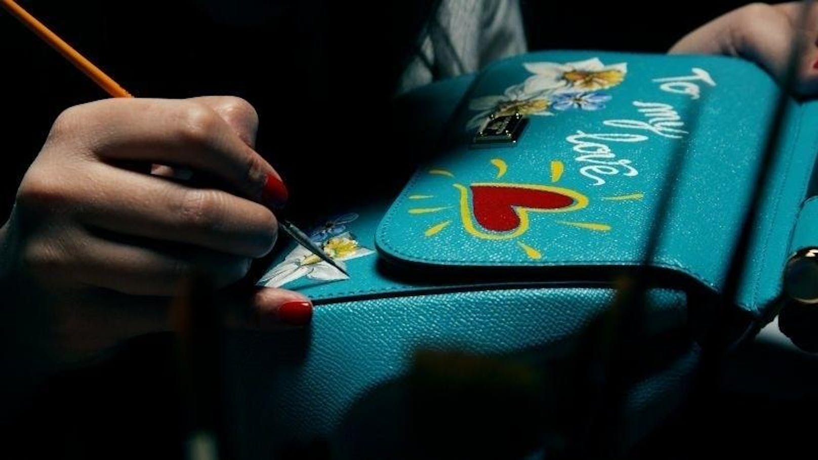 In Wien wird eine Künstlerin im Dolce&Gabbana Flagshipstore am Kohlmarkt Taschen von Kundinnen bemalen. (Foto: Dolce&Gabbana)