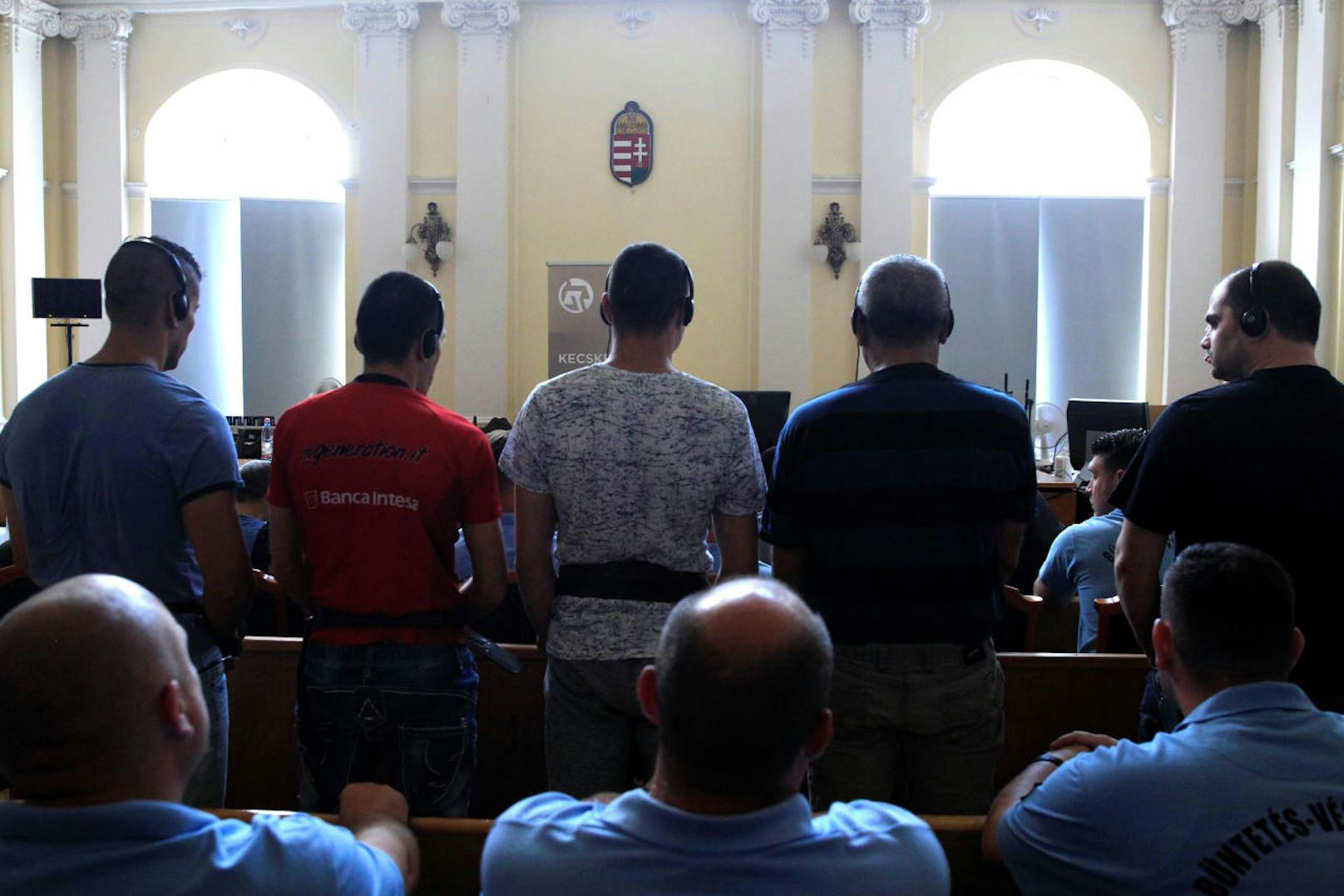 Unter schwerer Bewachung und in Handschellen sind am Mittwoch, 21. Juni 2017, zehn der elf Angeklagten im Schlepperprozess im Gericht in Kecskemet in Ungarn vorgeführt worden. Teils vermummte Justizwachebeamte begleiteten die Männer, die für den Erstickungstod von 71 Flüchtlingen verantwortlich sein sollen.