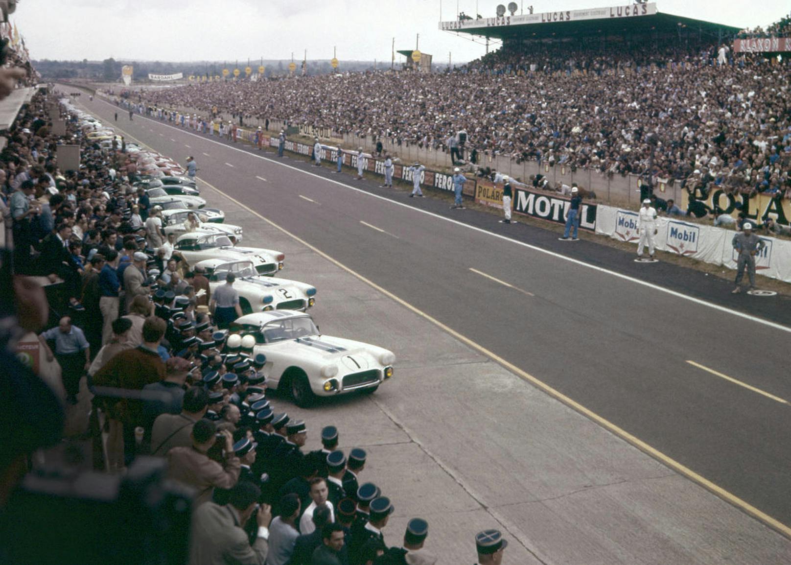Start zu den 24 Stunden von Le Mans im Jahr 1960. Die Piloten stehen rechts und warten auf die Startfreigabe, um dann über die Strecke zu spurten und loszufahren. Vier Corvettes starteten, Fitch/Grossman erzielten einen Klassensieg und Platz 8 - gegen Porsche, Aston Martin, Ferrari und diverse andere Konkurrenten.