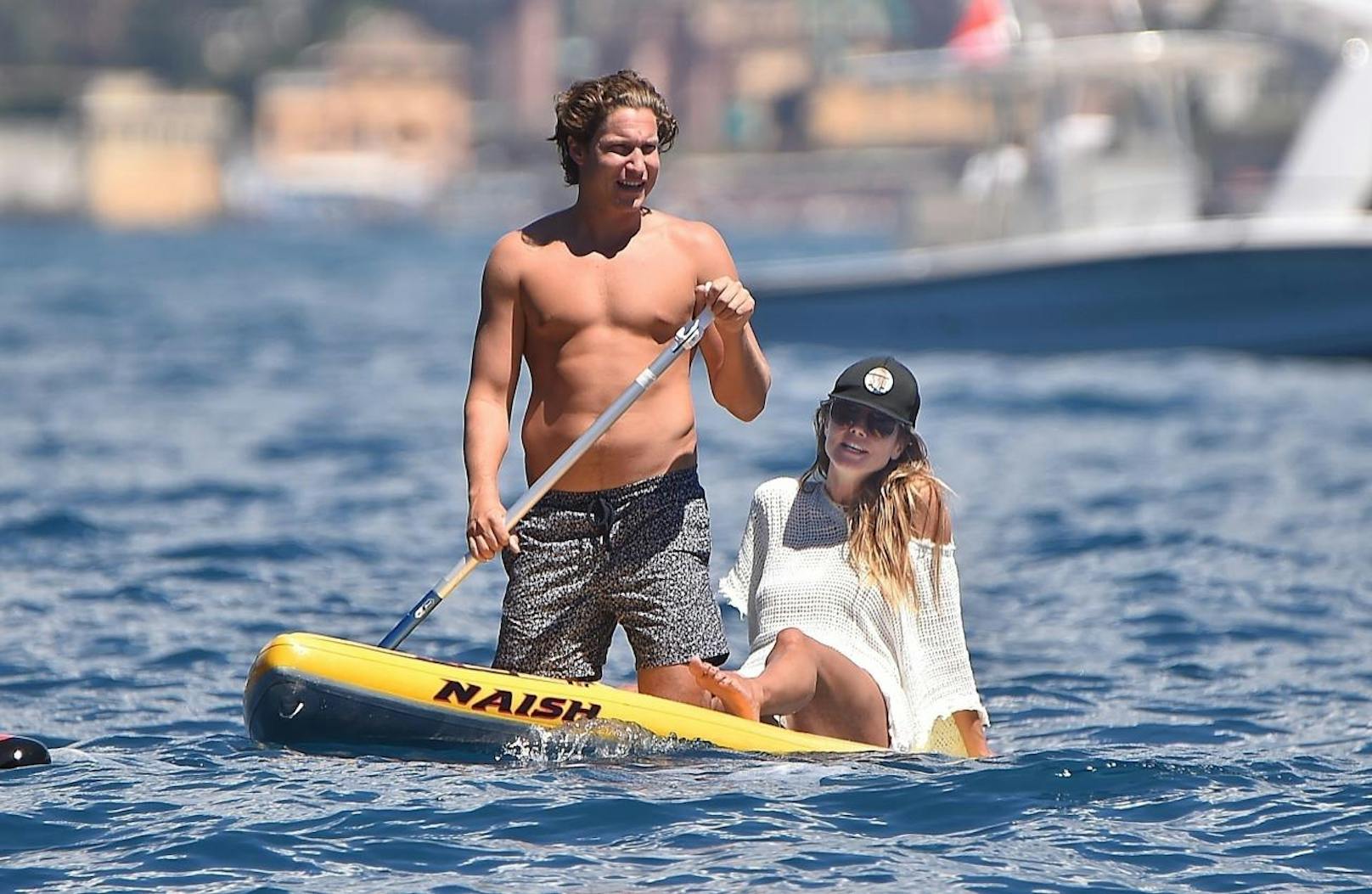Heidi und Vito haben Spaß beim Paddleboarding in Italien.