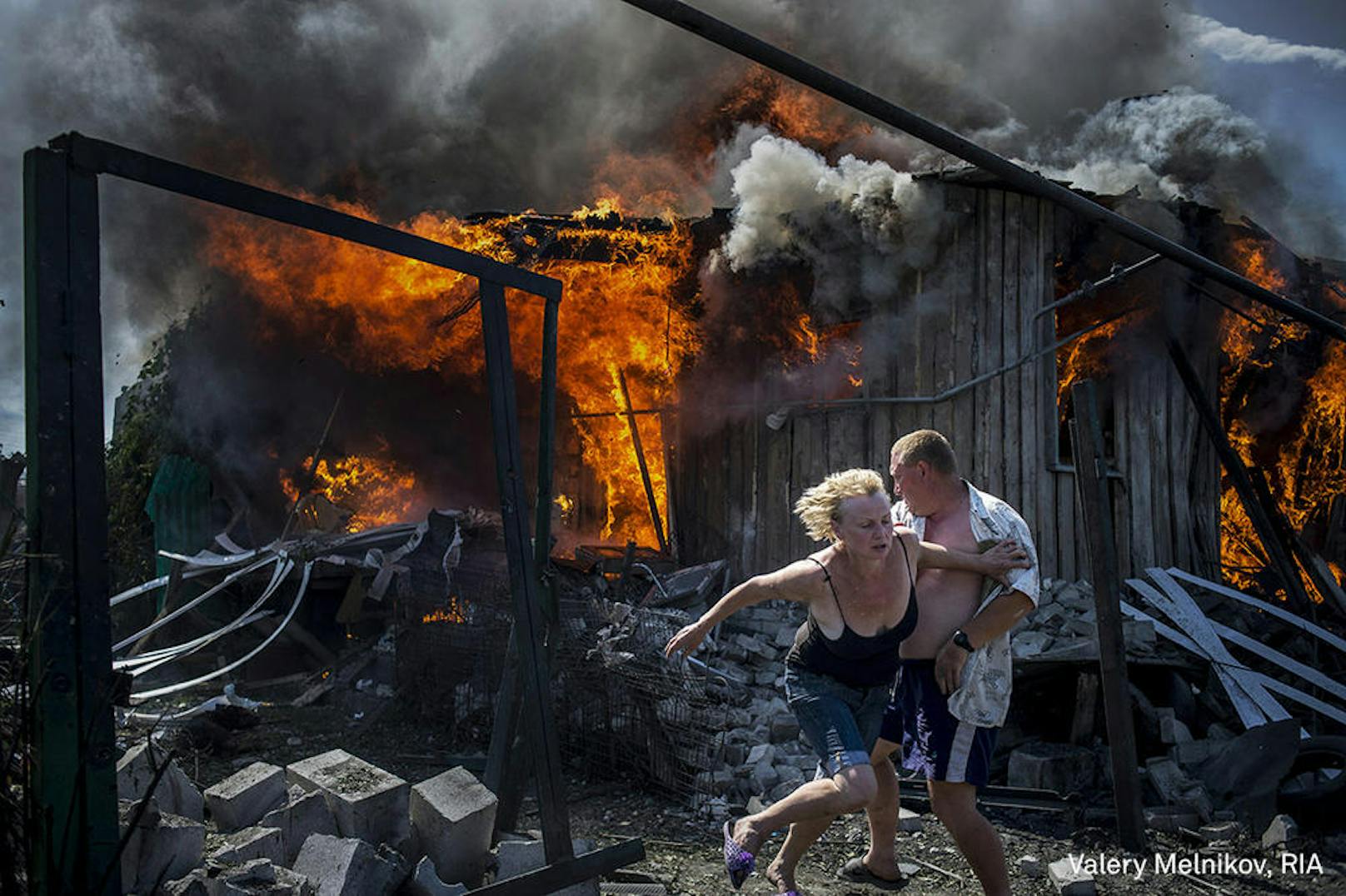 <b>Long-Term Projects - 1. Preis</b><br>Schwarze Tage der Ukraine <br>Nach einem Luftangriff auf das Dorf Luhanskaya flüchten Zivilisten aus ihren brennenden Häusern