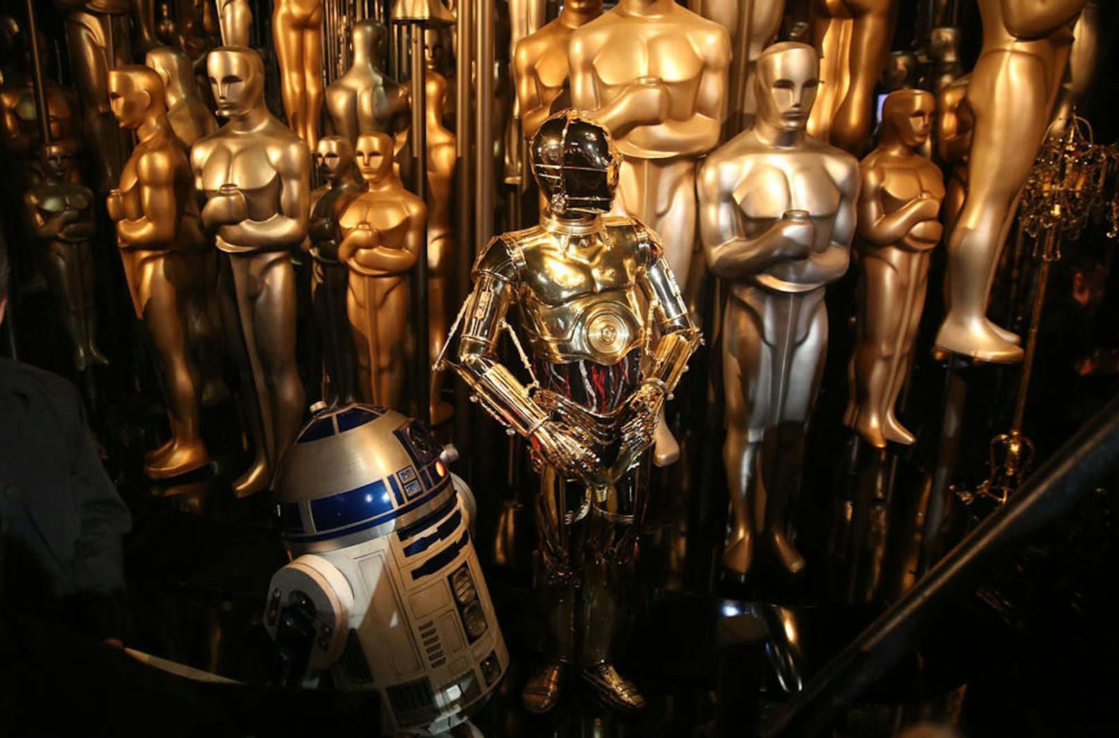 C3PO aus Star Wars neben seinen goldenen Freunden, den Oscar-Statuen