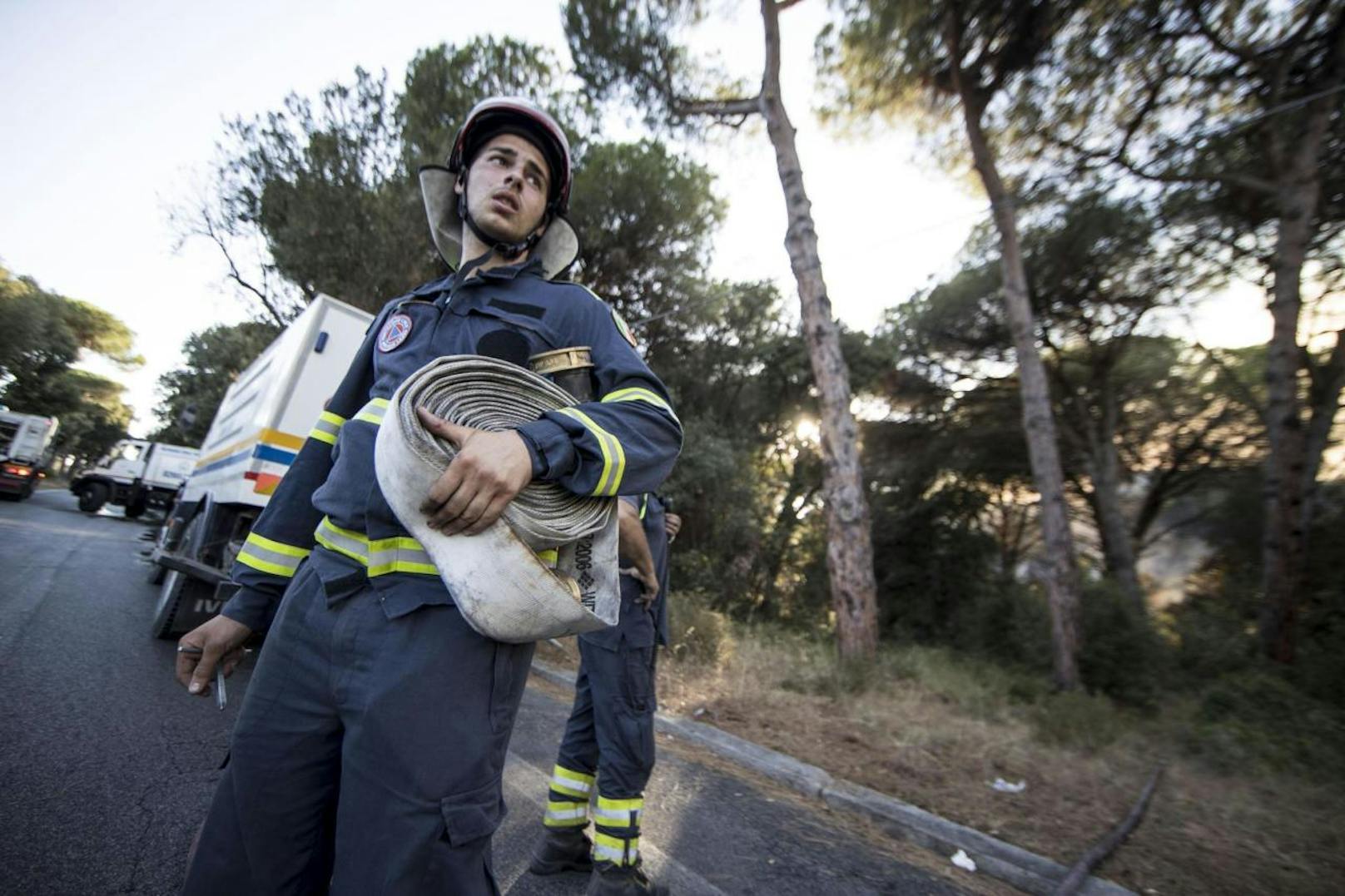 Feuerwehrmänner kämpfen mit den Flammen im Pinienwald von Castelfusano bei Rom