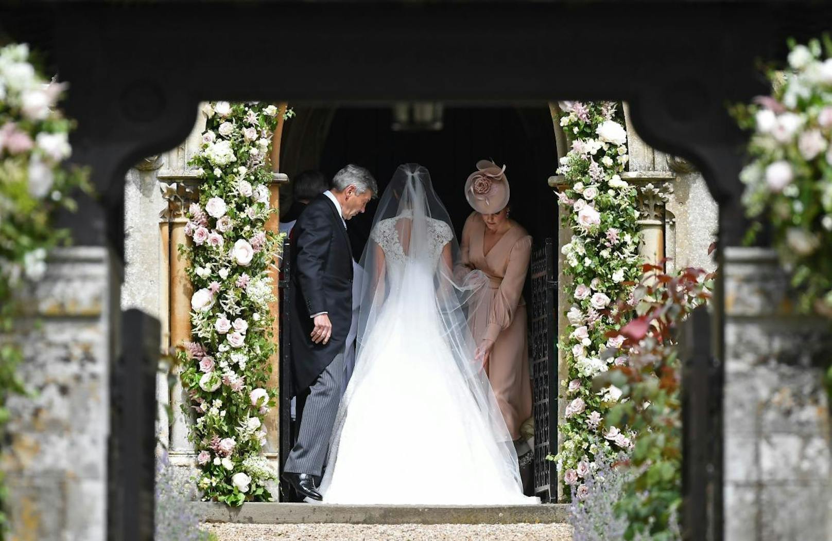 Herzogin Catherine trägt die Schleppe ihrer Schwester Pippa Middleton, die von ihrem Vater Michael Middleton zum Altar geführt wird. Vor sechs Jahren, auf der Hochzeit von Kate und William, war es umgekehrt. Dieser Auftritt von Pippa machte sie berühmt.