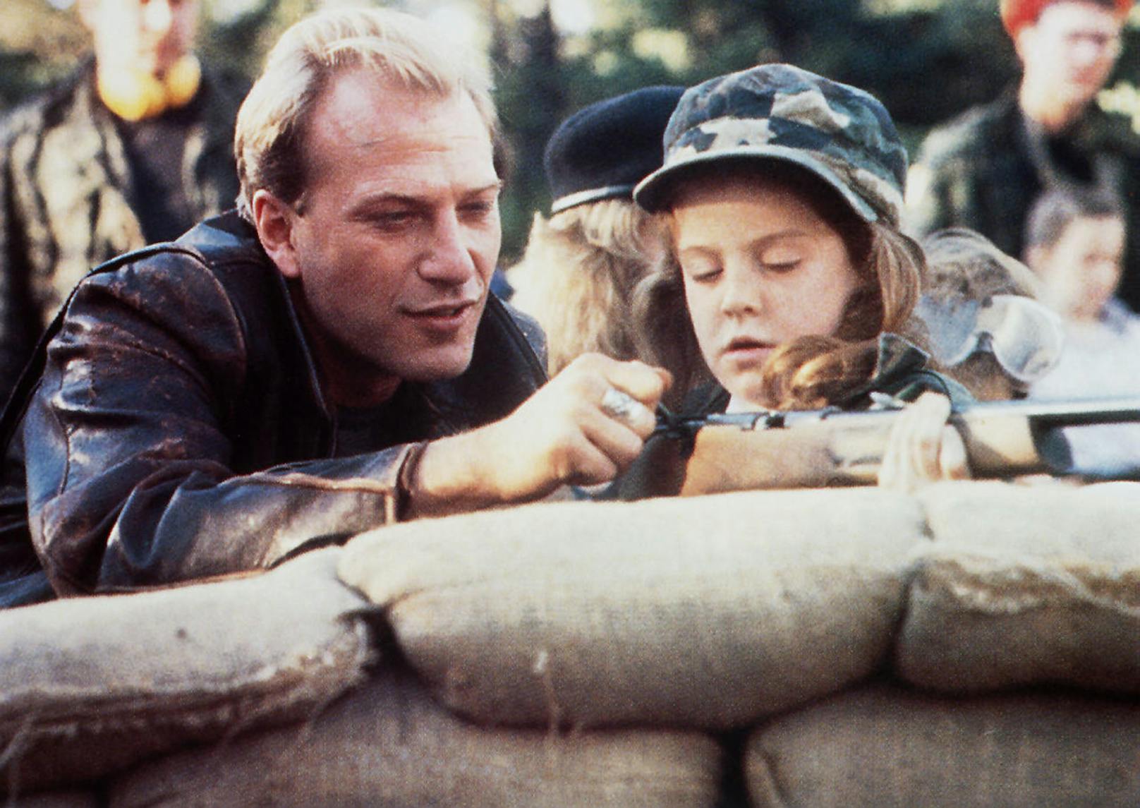 In "Verraten" (1988): Michael (John Heard) zeigt der kleinen Gladys (Betsy Blair) wie eine Waffe funktioniert.