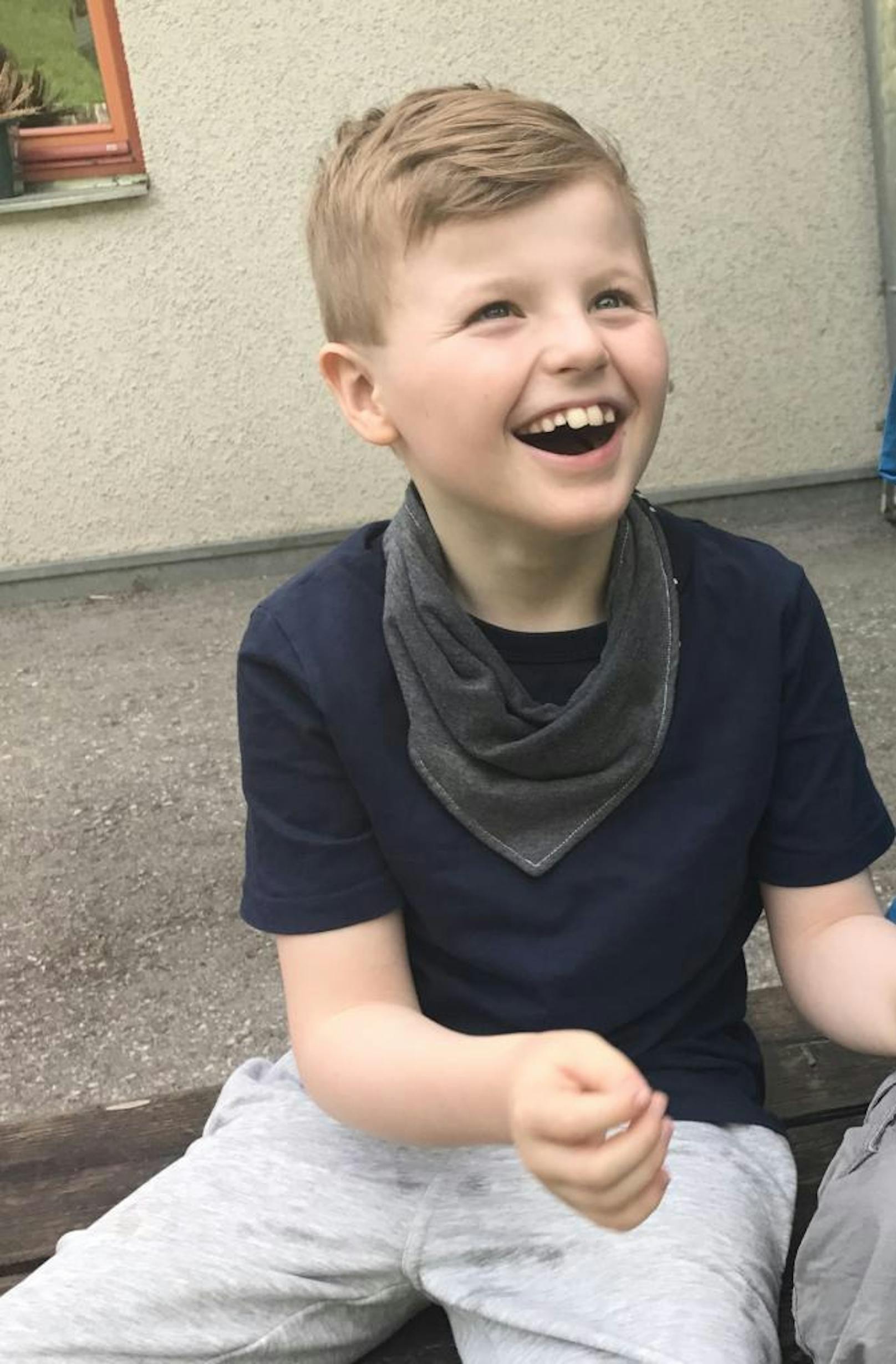 Der 8-Jährige ist mit dem Angelman-Syndrom geboren. Häufiges Lachen ist charakteristisch.