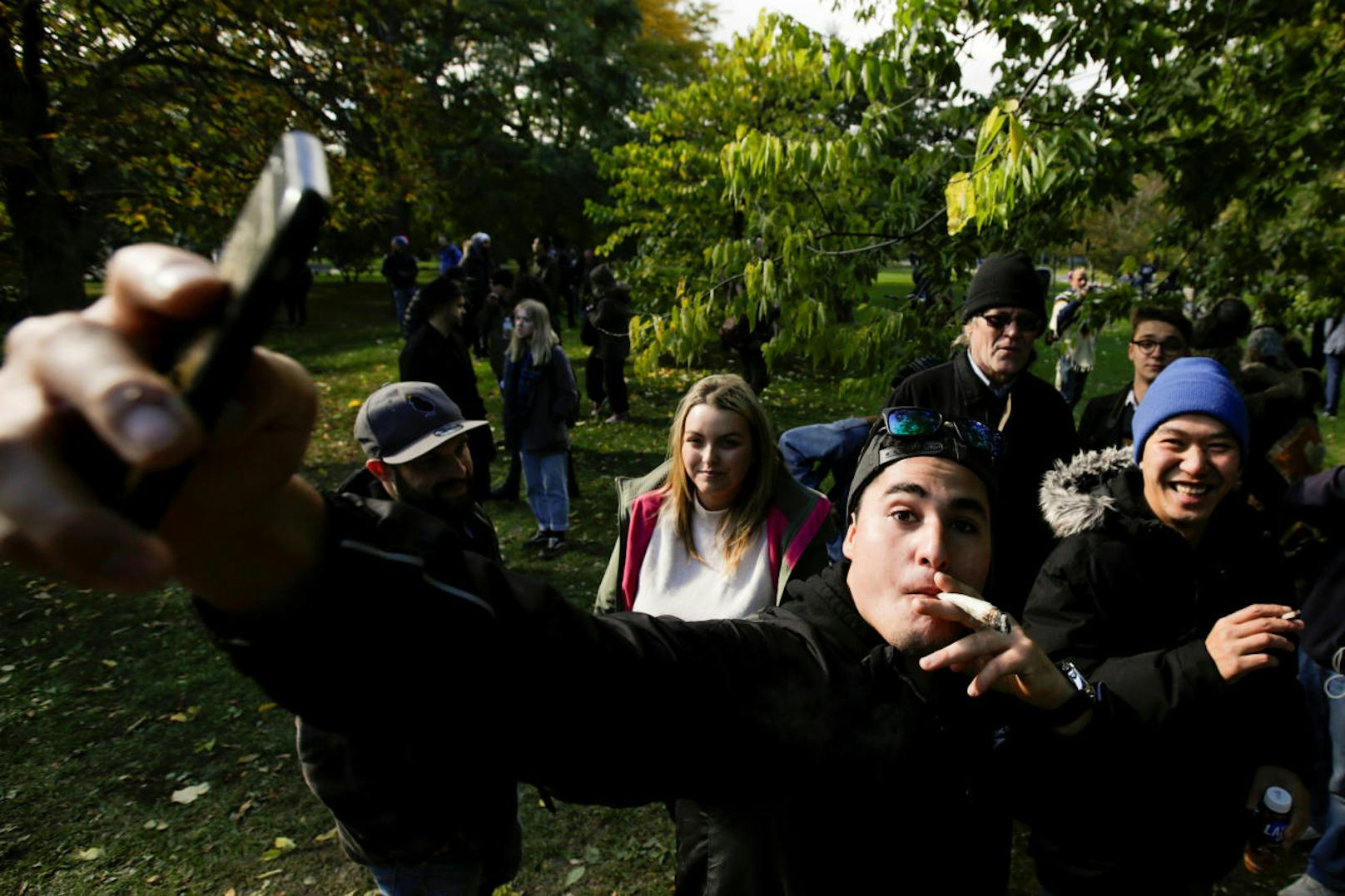 Cannabis-Fans feiern die Legalisierung mit Selfies im Park.