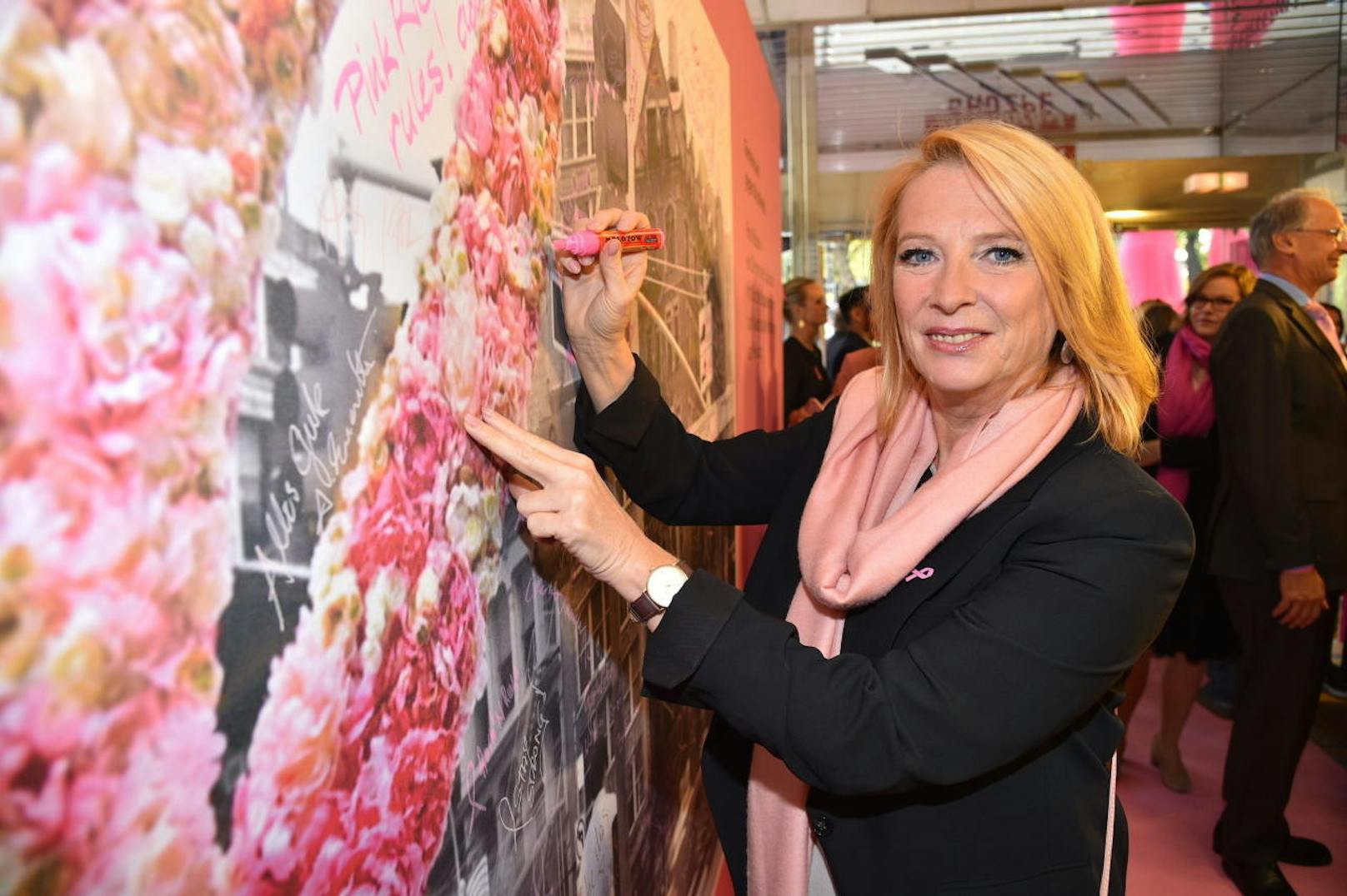 Doris Bures verewigt sich auf der Pink Ribbon Jubiläumswand