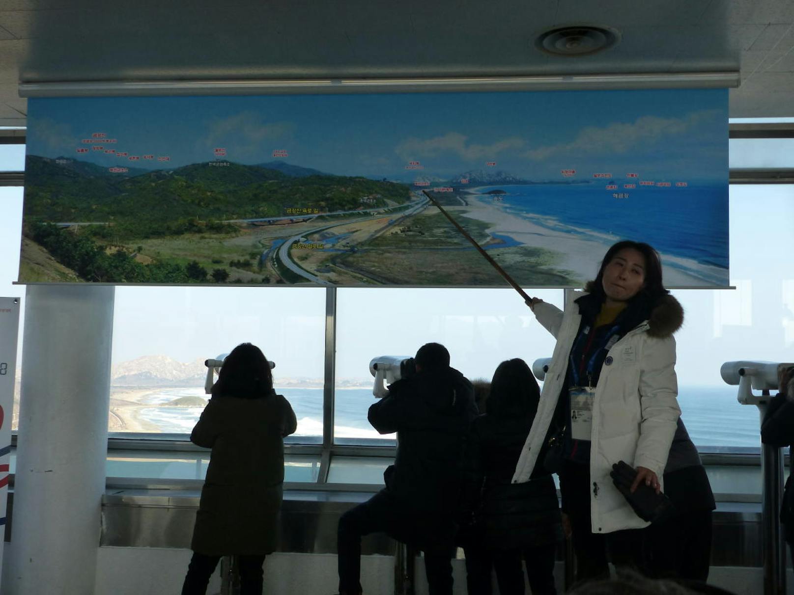 Reiseleiterin Shin erklärt die Demarkationslinie, die vom Aussichtspunkt aus zu sehen ist. Die anwesenden Soldaten dürfen nicht fotografiert werden.