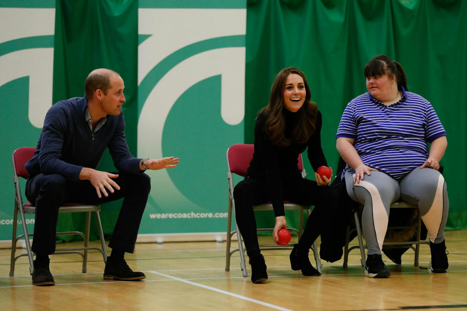 BASILDON, ENGLAND - OCTOBER 30:  Prince William, Duke of Cambridge and Catherine, Duchess of Cambridge play boccia with a participant as they join a session during a visit to the Coach Core Essex apprenticeship scheme at Basildon Sporting Village on October 30, 2018 in Basildon, England. (Photo by Adrian Dennis - WPA Pool/Getty Images)