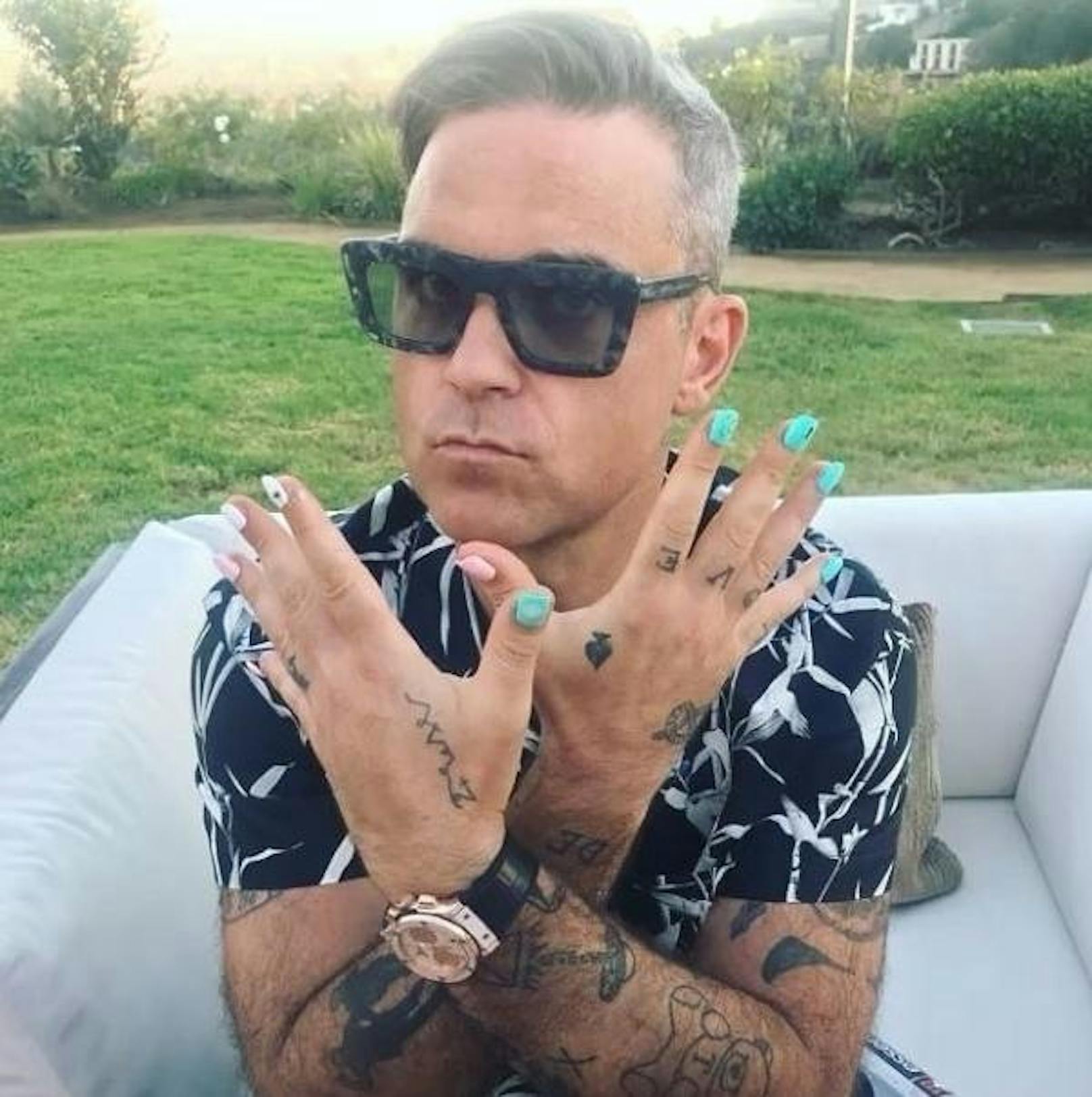 26.09.2018: Als "Väterliche Pflichten" bezeichnet Robbie Williams seine jadegrün lackierten Fingernägel auf Instagram. Seine sechsjährige Tochter nahm ihn wohl als Übungsobjekt in Anspruch.