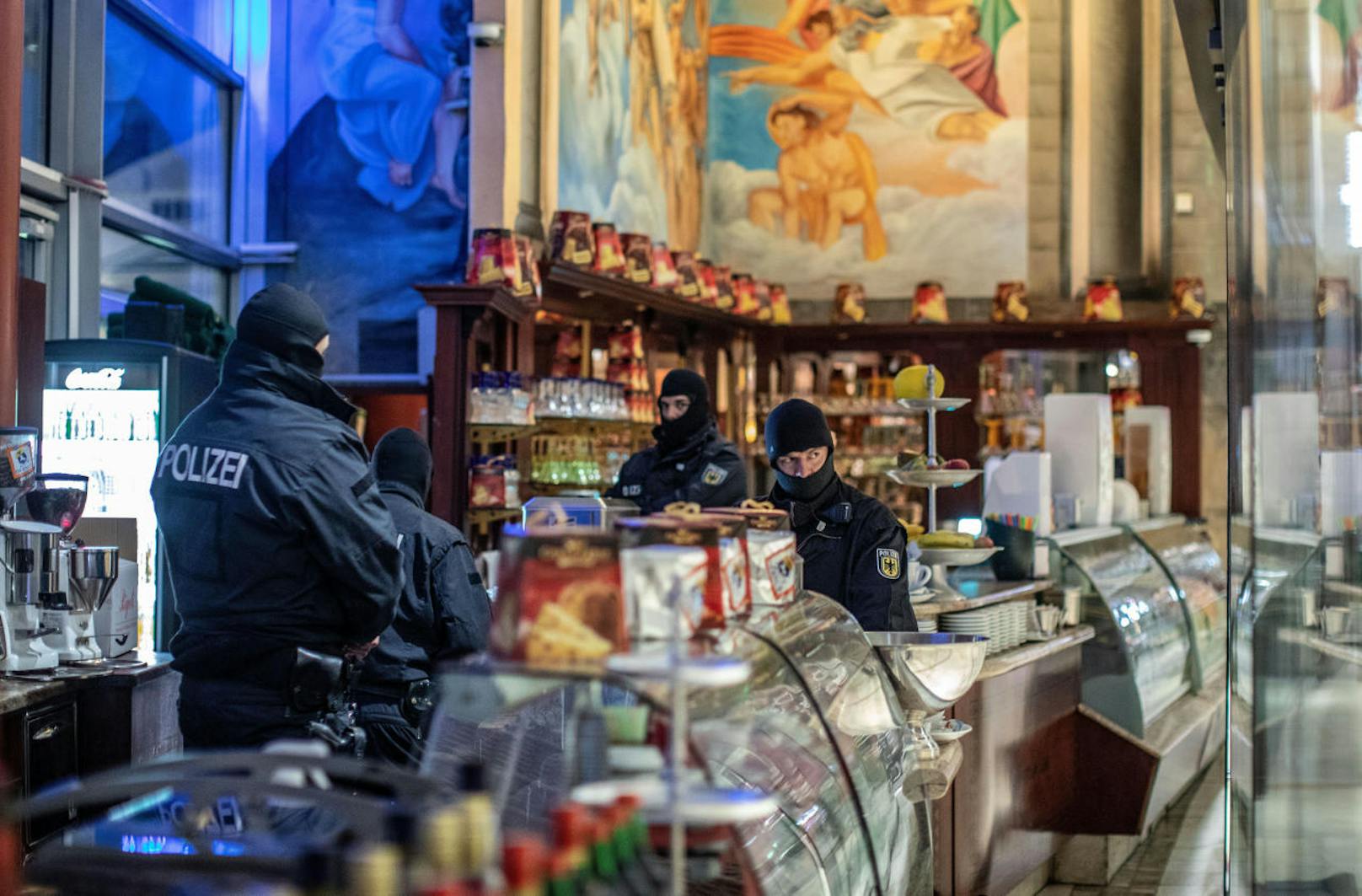 Nein, sie kaufen nichts: Deutsche Polizisten während einer Razzia gegen die Mafia-Organisation 'Ndrangheta in einem Eis-Geschäft im Zentrum von Duisburg (Nordrhein-Westfalen) am 5. Dezember 2018.