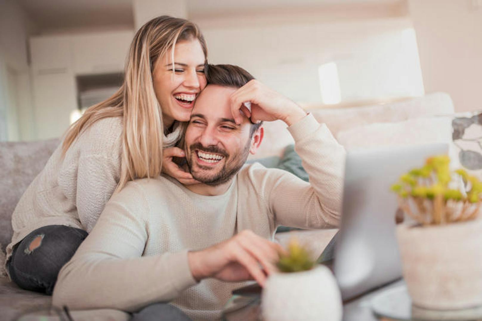 Close up of young couple working on laptop at home.