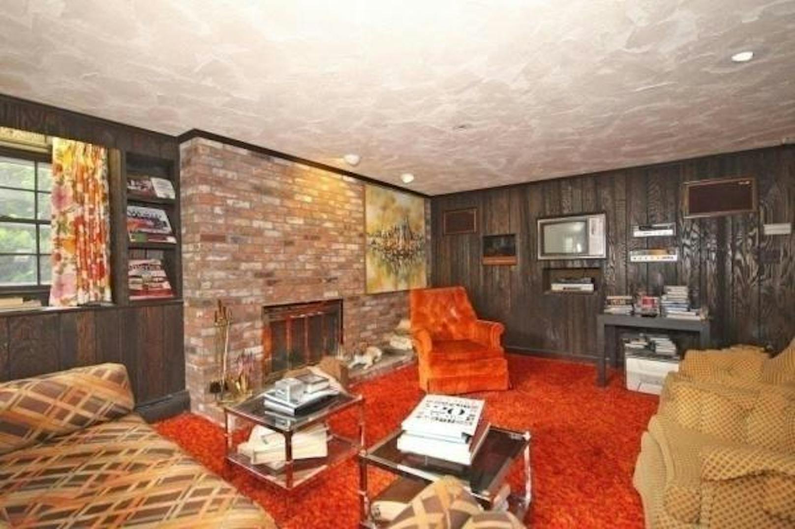 Das Haus hat 334 Quadratmeter. Ein kultiger, oranger Flauschteppich und der passende Sessel zieren das Wohnzimmer.
