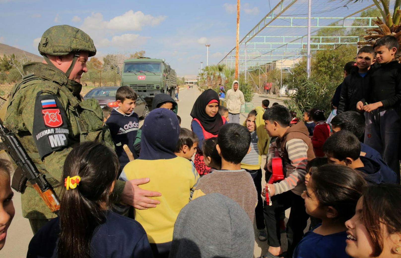Ein russischer Soldat mit syrischen Kindern in einem provisorischen Lager für Zivilisten, die aus der islamistischen Rebellenhochburg Ost-Ghouta fliehen
