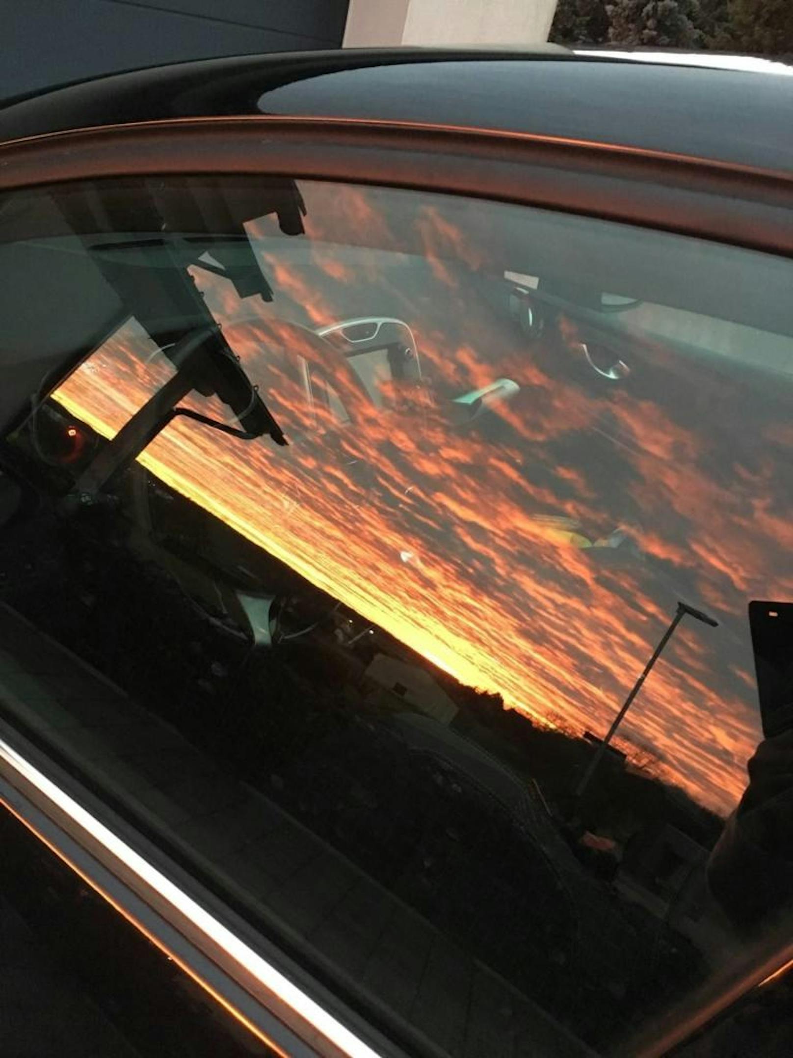 "Der Sonnenaufgang spiegelt sich im Fenster meines Autos."
