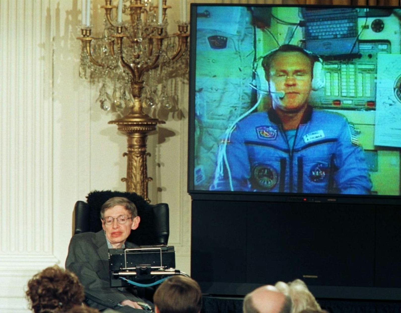 Stephen Hawking bei einer Vorlesung im Weißen Haus mit einer Live-Verbindung zu Astronaut David Wolf auf der Raumstation Mir.