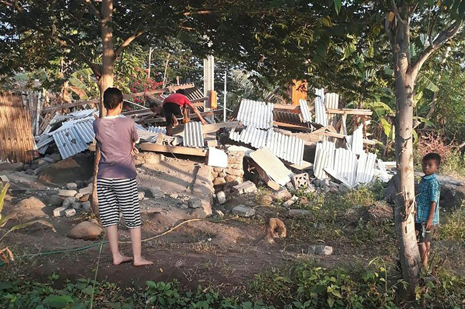 Das Beben ereignete sich in einer Tiefe von 24 Kilometern: Ein Mann klettert über die Trümmer seines Hauses in Lombok am 29. Juli 2018.