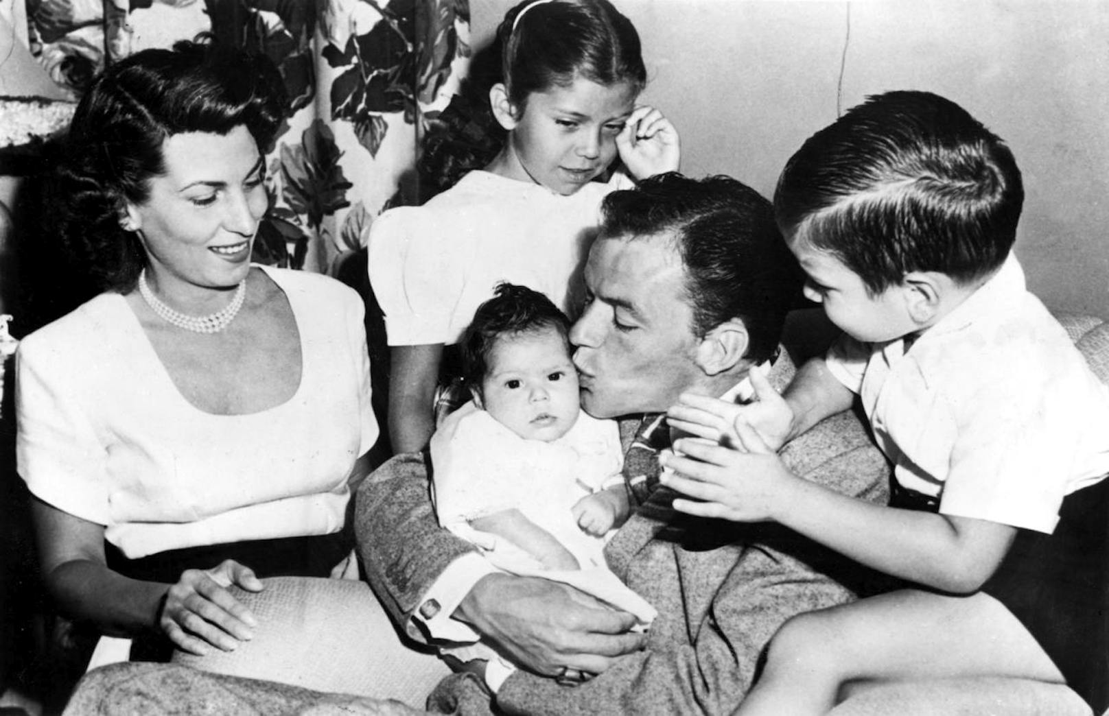 Der legendäre Entertainer Frank Sinatra (m.) im Beisein seiner Ehefrau Nancy Sinatra und den drei gemeinsamen Kindern, Nancy Jr., Frank Jr. und der gerade neugeborenen Christina (1948).