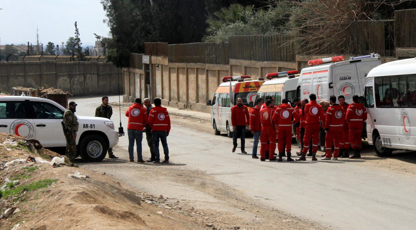 Freiwillige Helfer und Rettungsfahrzeuge des Roten Halbmondes warten auf evakuierte Zivilisten und Verletzte aus Ost-Ghouta.