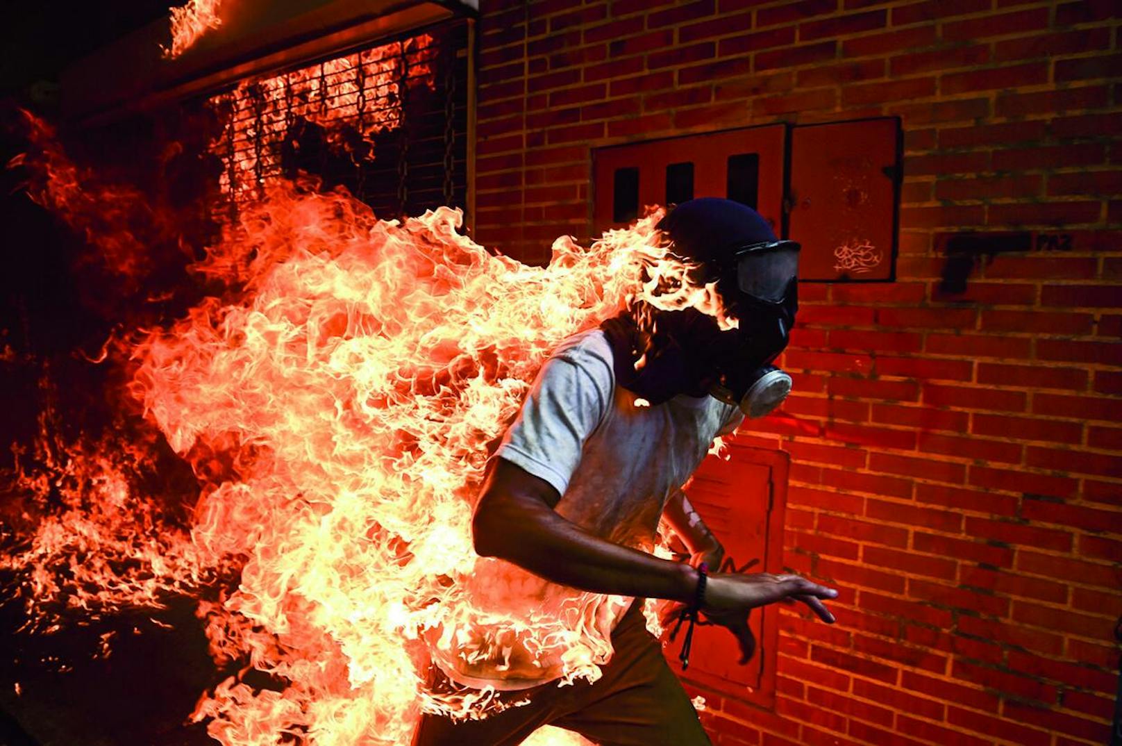 "World Press Photo des Jahres": 3. Mai 2017

Maduro wollte das von der Opposition dominierte Parlament durch eine verfassungsgebende Versammlung ersetzen und sich damit die gesetzgeberischen Befugnisse faktisch selbst sichern. Oppositionsführer riefen zu Massenprotesten auf, um vorgezogene Präsidentschaftswahlen zu verlangen. Am 3. Mai kam es zu Ausschreitungen zwischen Demonstranten und der Nationalgarde. Die Demonstranten, viele mit Kapuzen, Masken oder Gasmasken, entzündeten Feuer und warfen mit Steinen. Der 28- jährige José Victor Salazar Balza geriet in Brand, als der Tank eine Motorrads explodierte. Er überlebte mit Verbrennungen ersten und zweiten Grades.