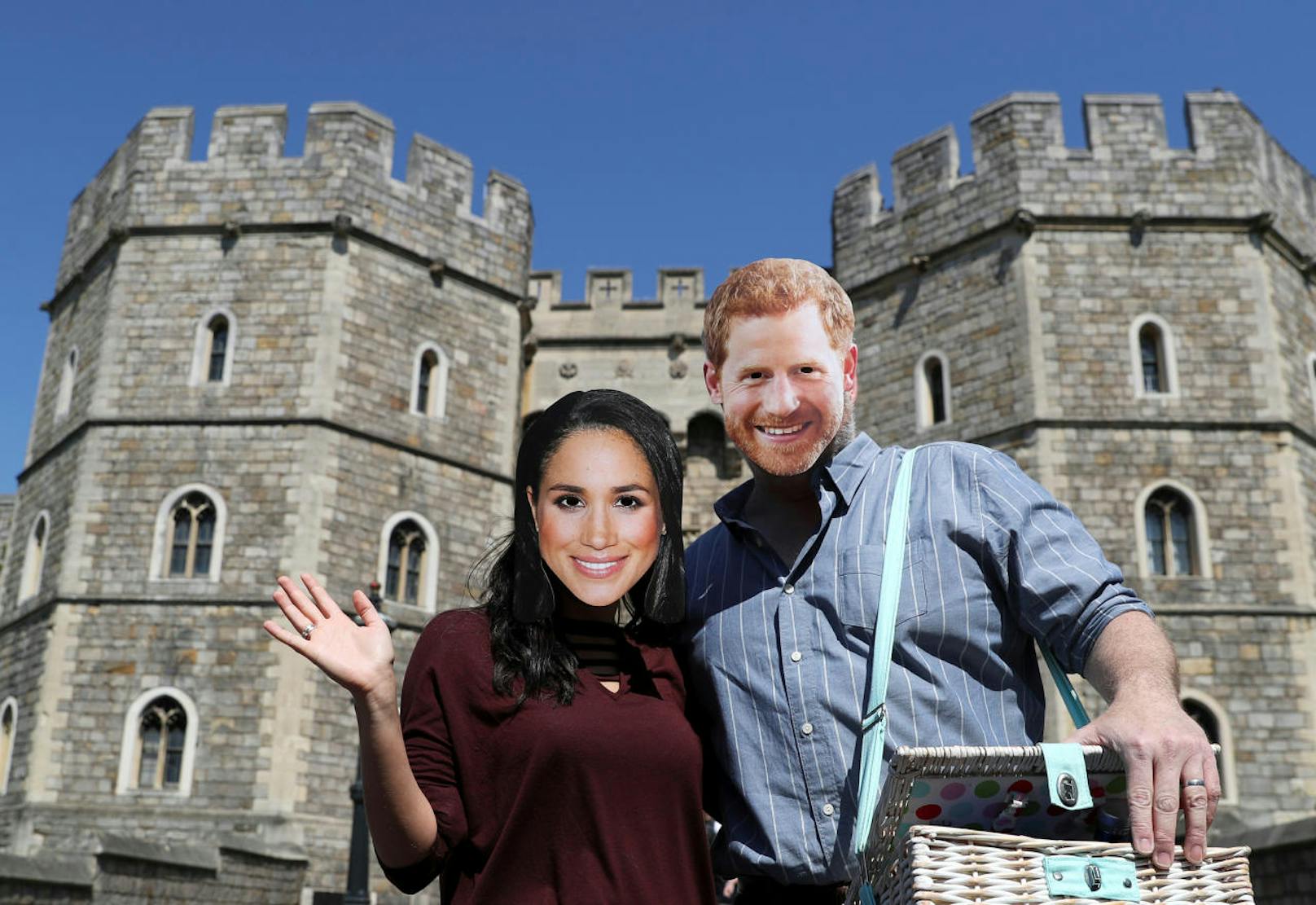 Dieses Paar hat Meghan- und Harry-Masken mitgebracht und posiert vor dem Windsor Castle