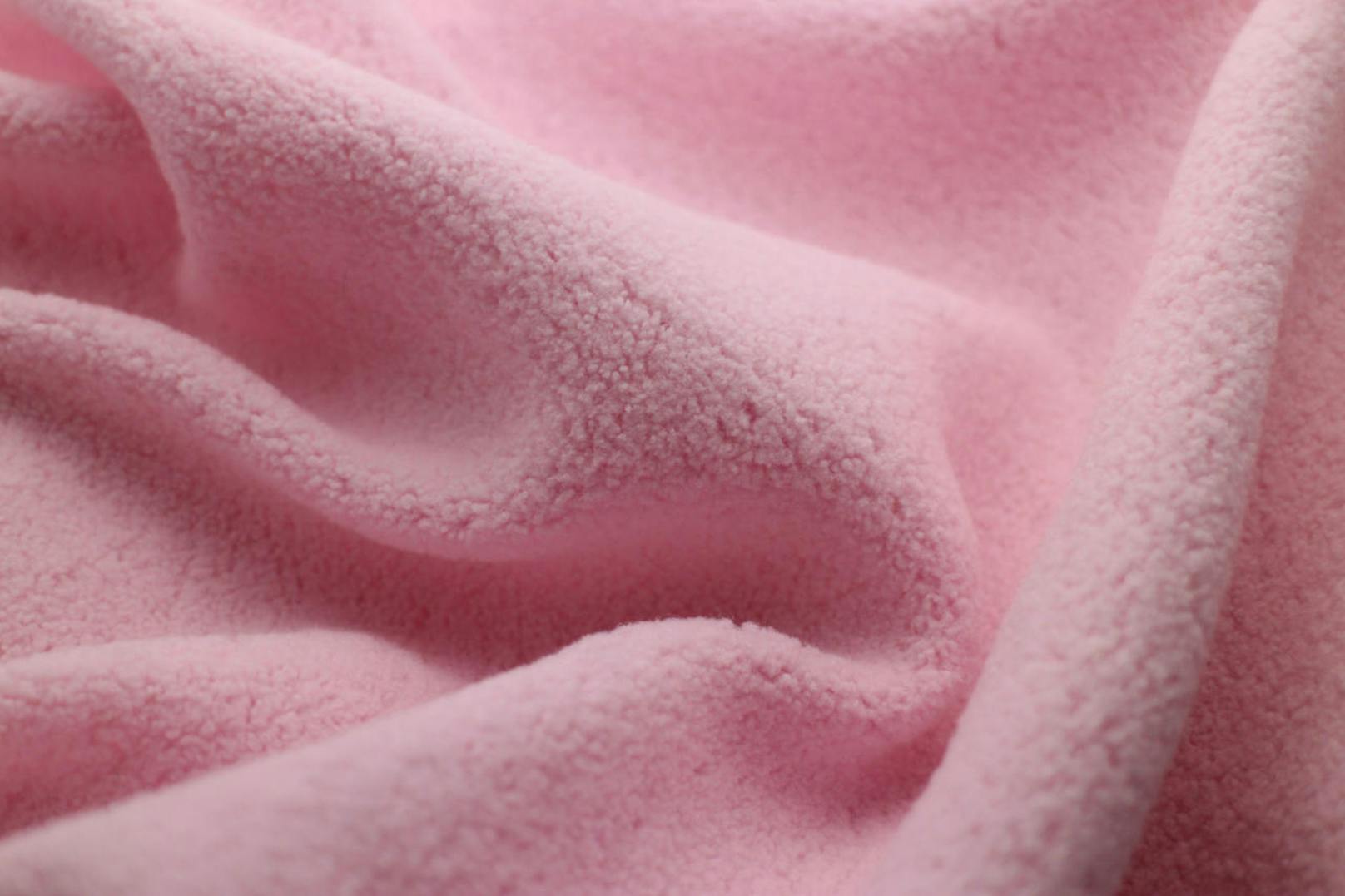 Der synthetisch fabrizierte Fleece-Stoff aus Polyester isoliert gut gegen Kälte, ist widerstandsfähig und langlebig.