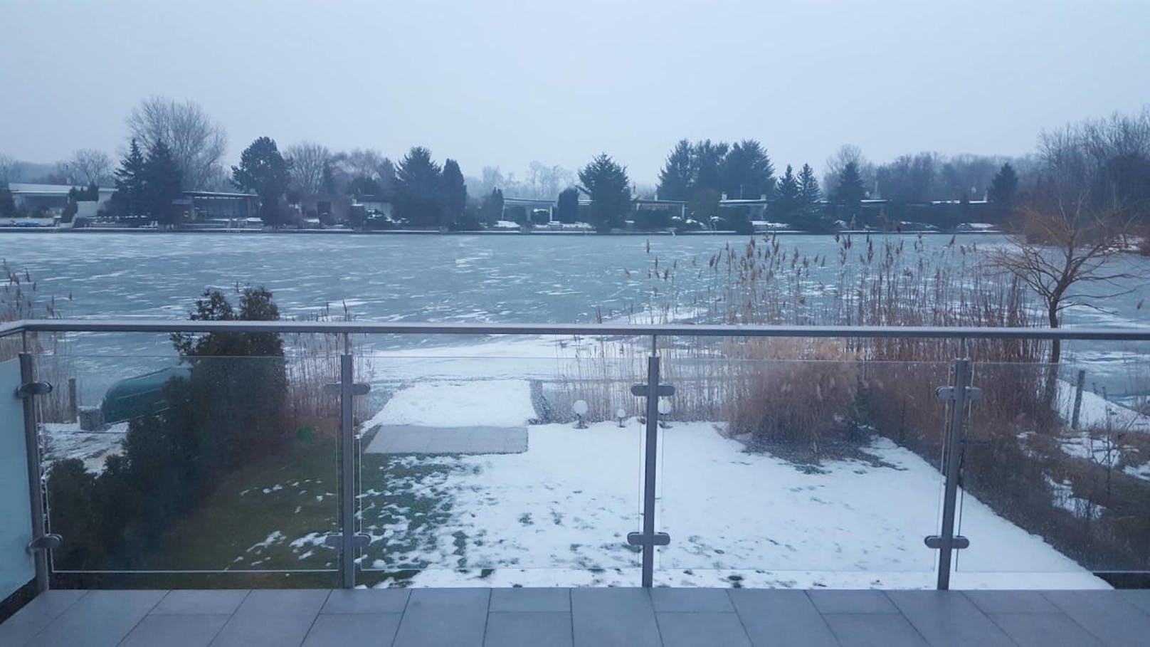 "Morgendlicher Blick vom Wintergarten-Fenster auf den noch eisbedeckten See!"