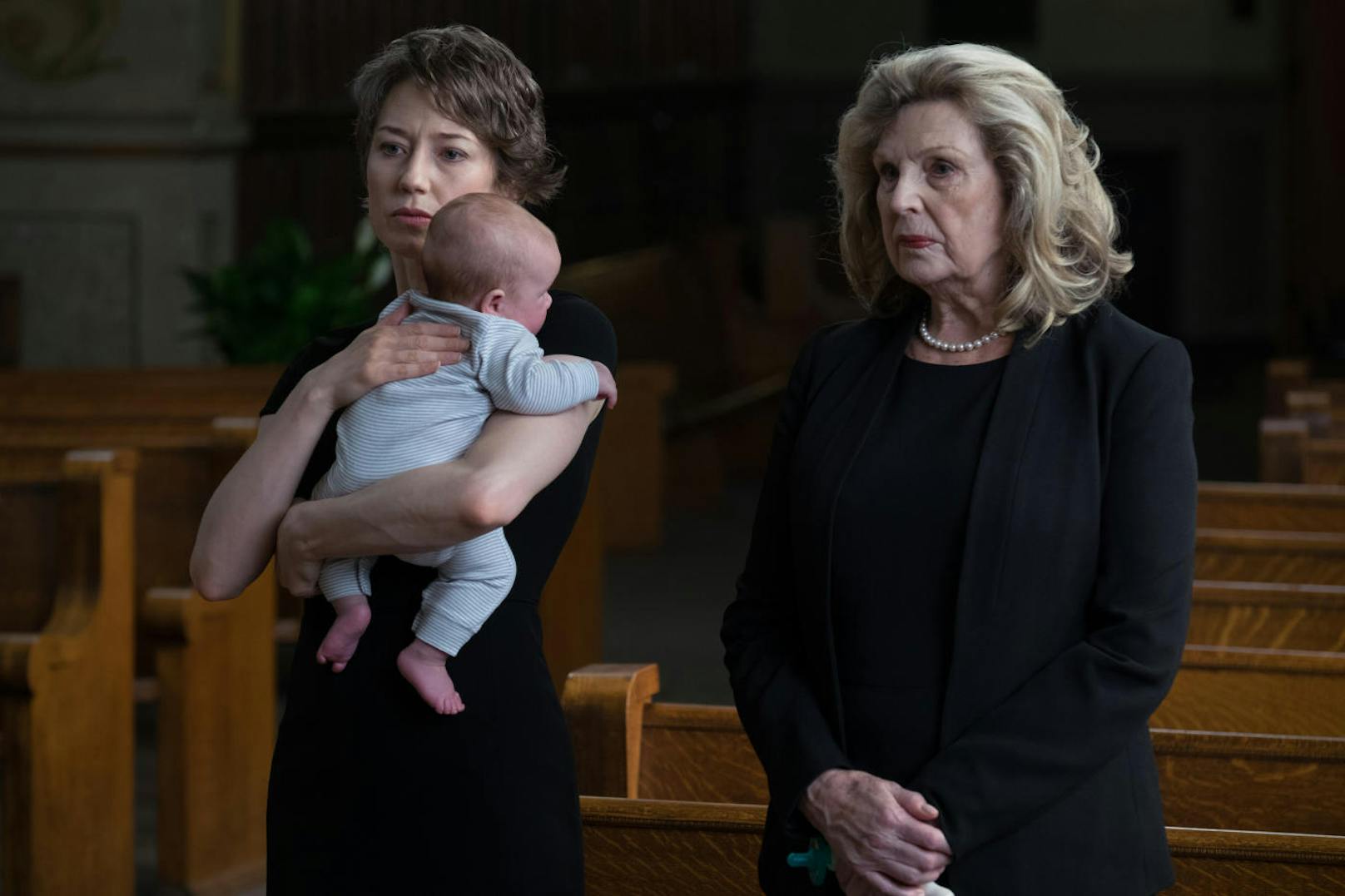 Eine der Witwen steht mit ihrem kleinen Baby allein da (Jacki Weaver, Carrie Coon)