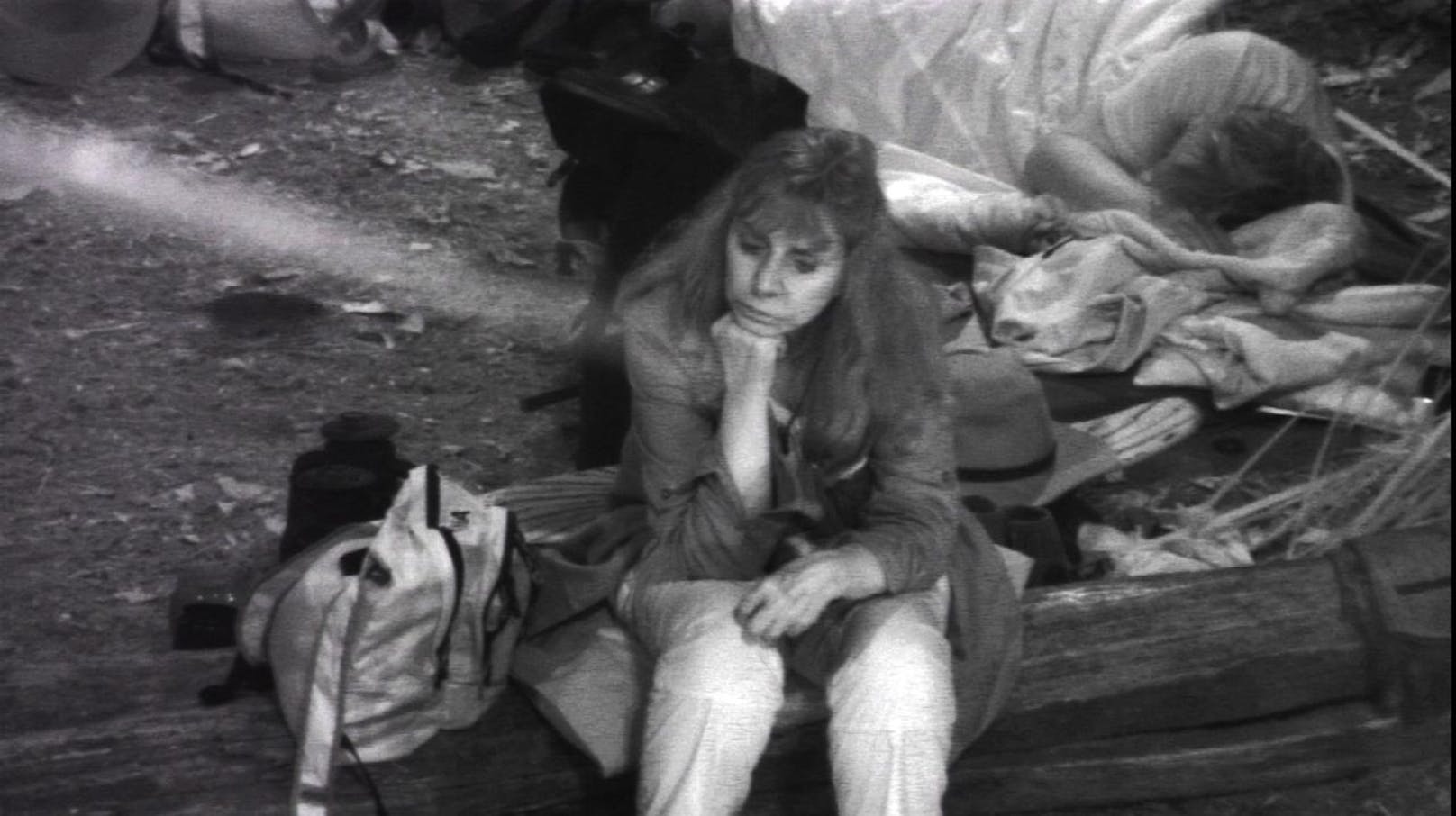 Tina York sitzt wieder alleine am Lagerfeuer. Hinter ihr schläft Ansgar Brinkmann.