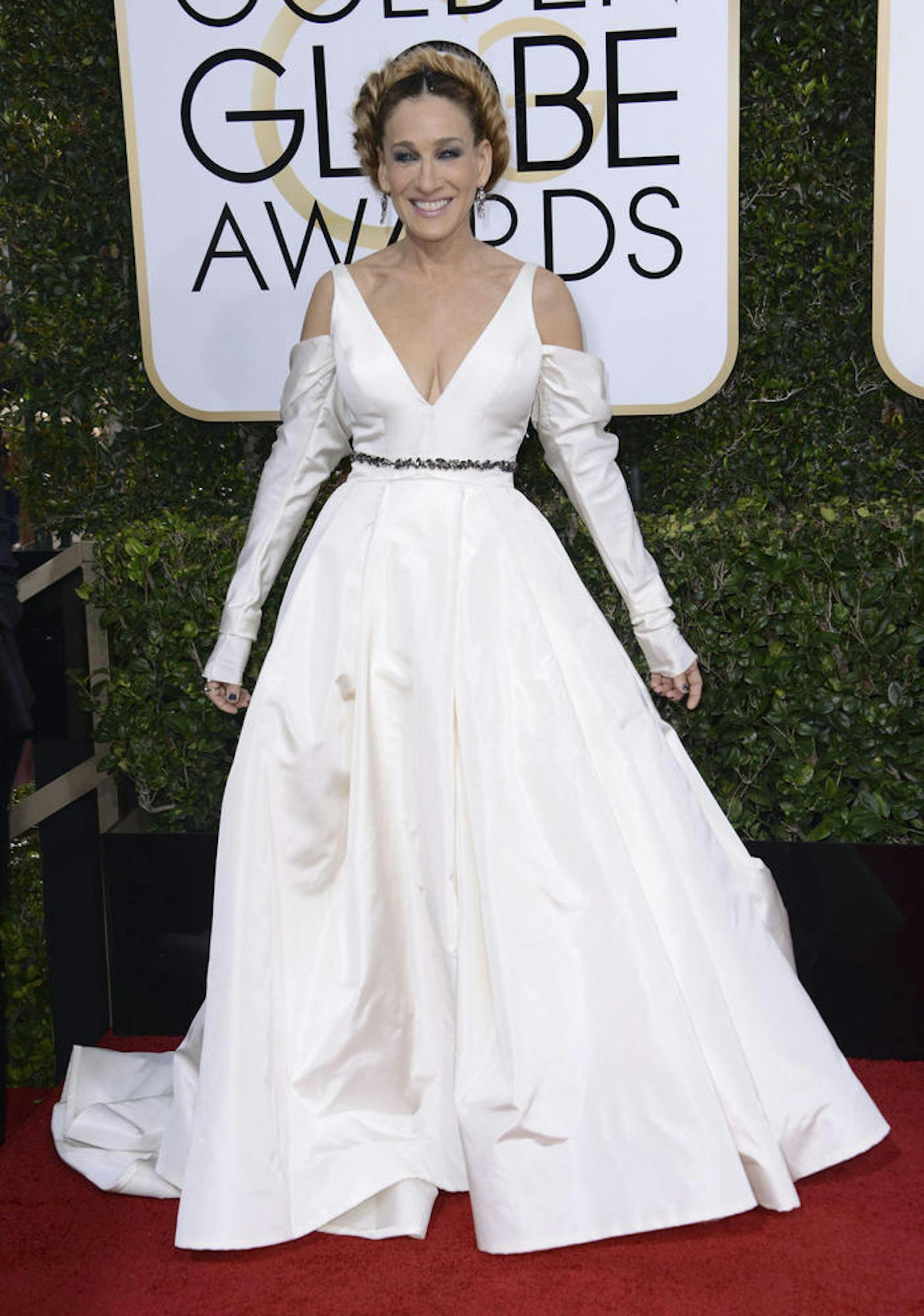 Sarah Jessica Parker trägt ein weißes, weit ausgestelltes Kleid, das irgendwie an ein Hochzeitskleid erinnert...