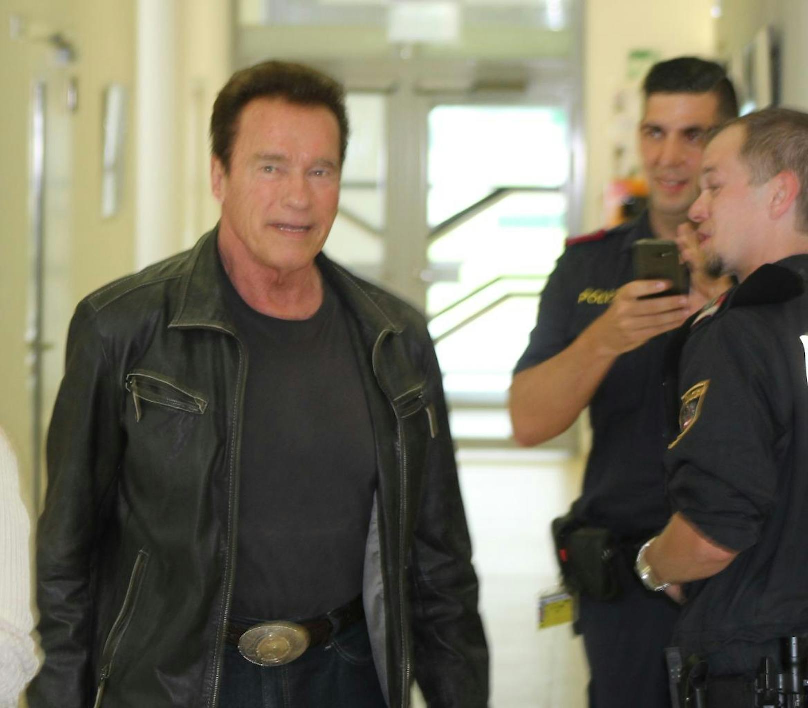 Arnie marschiert in dunkler Kluft durch einen Korridor. Nein, keine Szene aus "Terminator 2" ... 