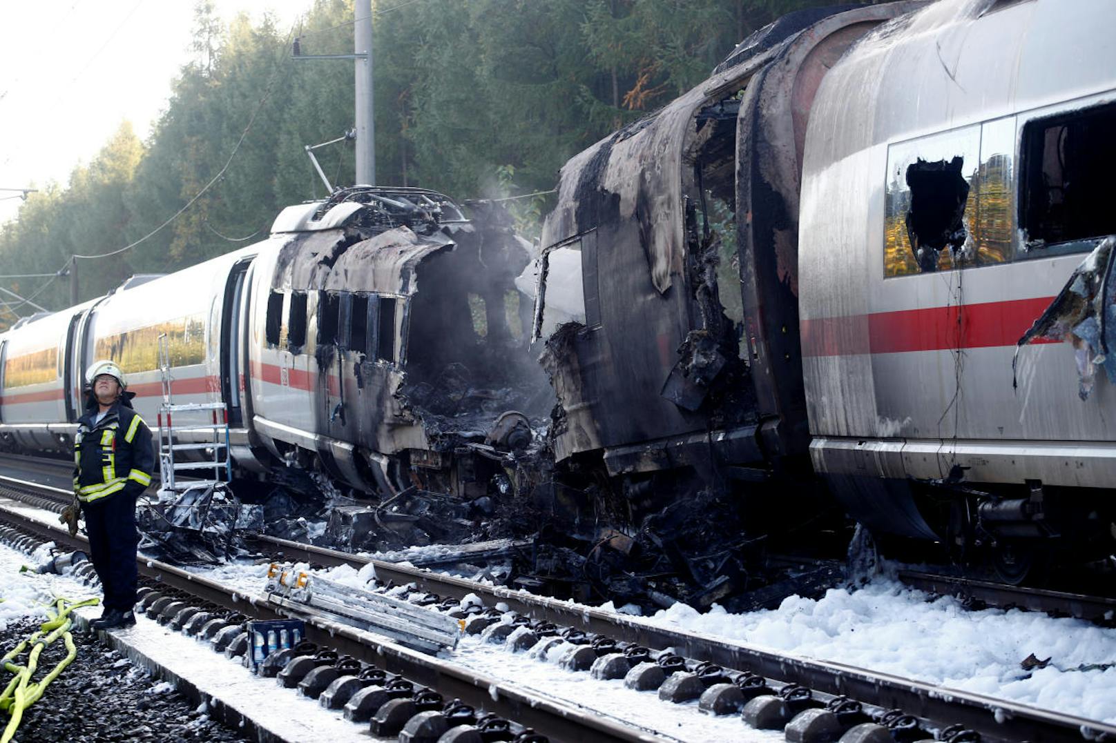A firefighter stands beside a German high speed ICE train after it caught fire on the way from Cologne to Frankfurt in Dierdorf, Germany, October 12, 2018.     REUTERS/Wolfgang Rattay - RC1AEAAFBE70