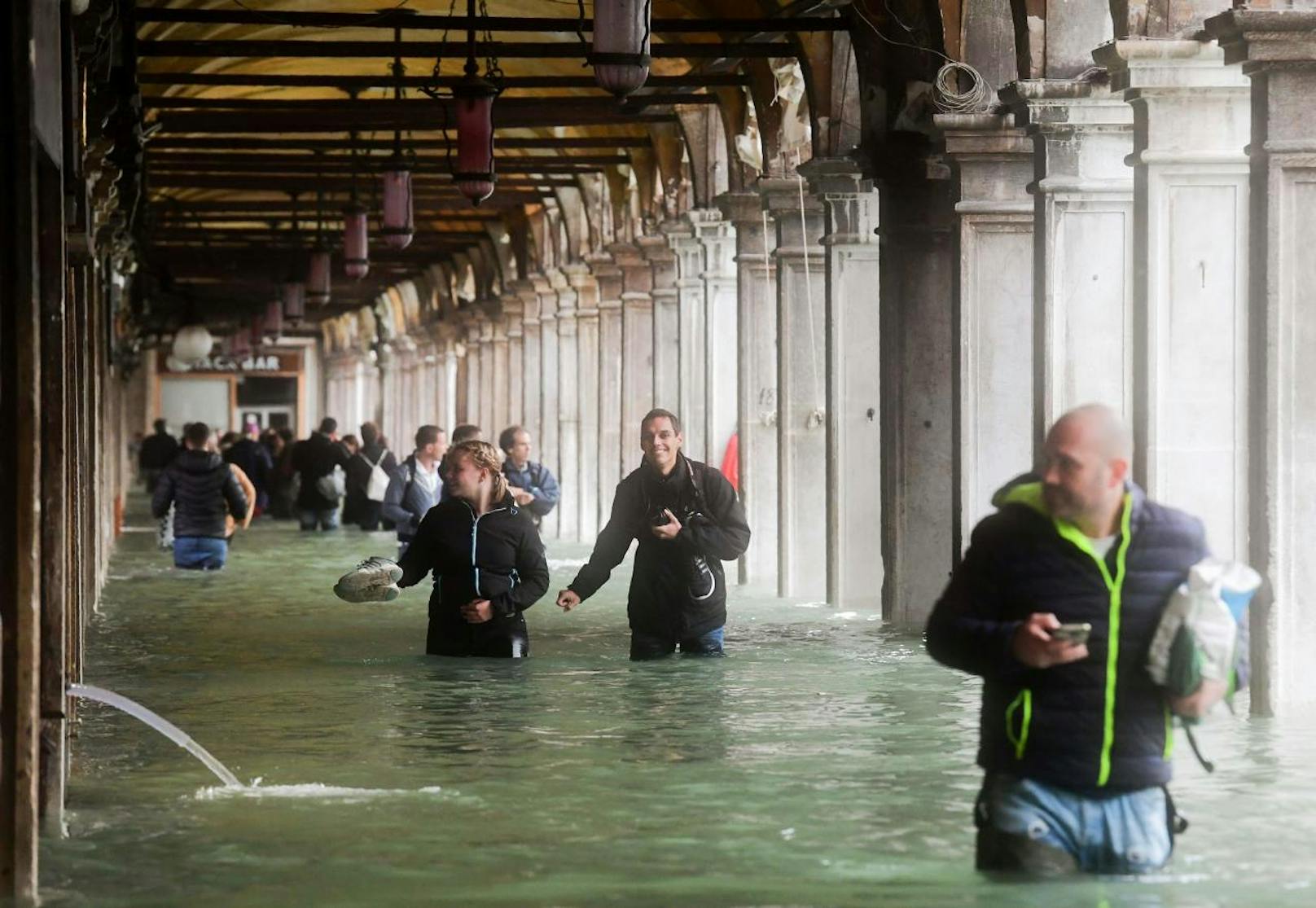 Touristen marschieren durch die Flut. 