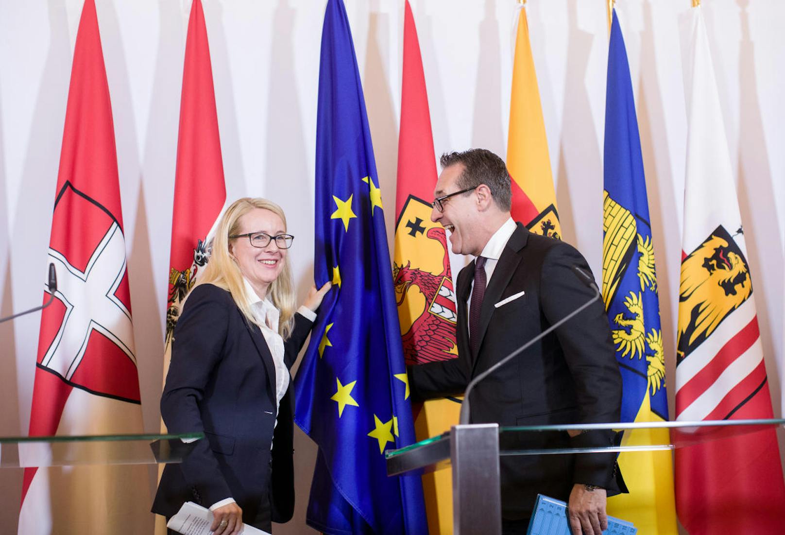 ÖVP-Wirtschaftsministerin Margarete Schramböck und Heinz-Christian Strache (FPÖ) richteten die umgefallene EU-Fahne gemeinsam wieder auf .