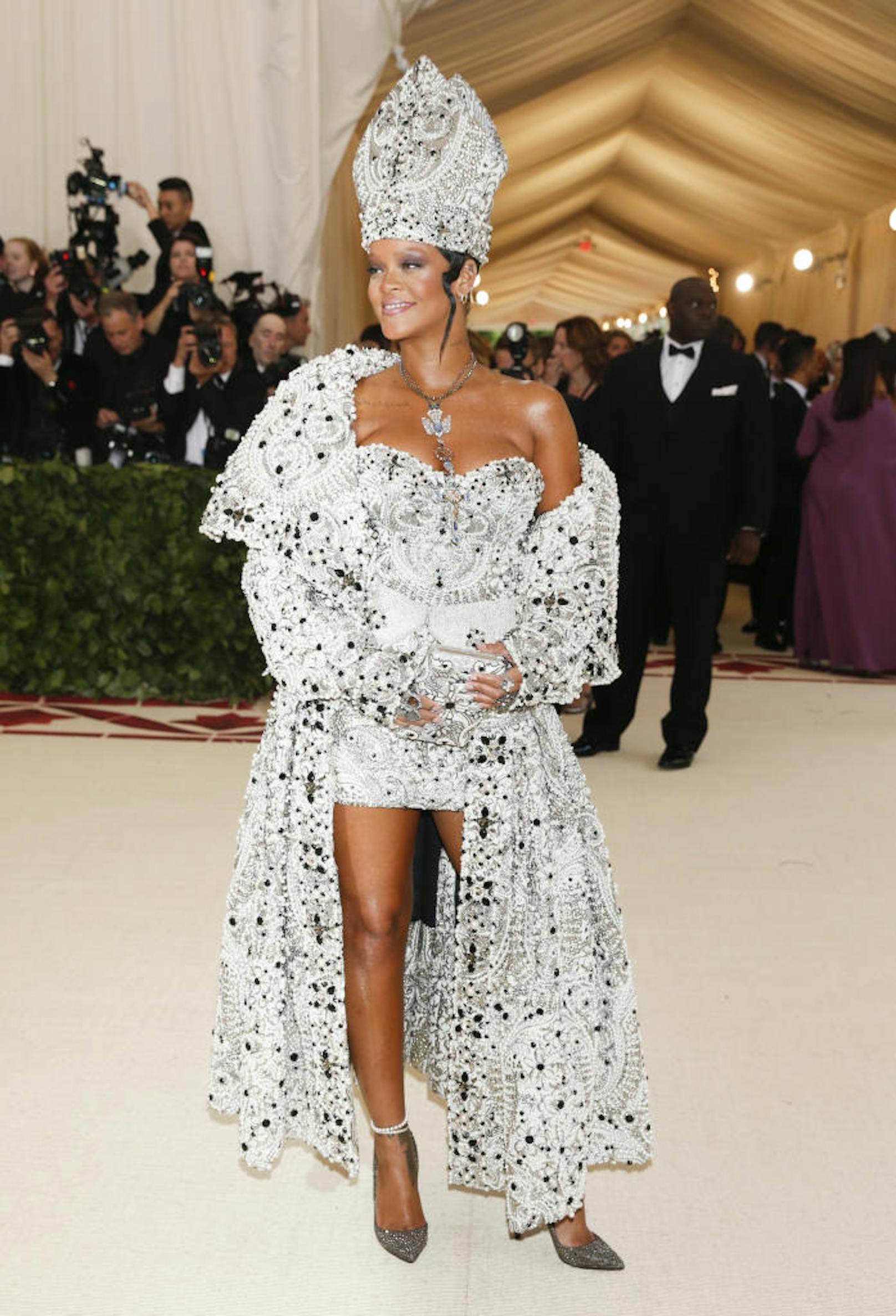 Rihanna hat sich wohl kurzfristig selbst zur ersten weiblichen Päpstin ernannt. Die Sängerin erschien in einer Maison Margiela Kreation von John Galliano, inklusive päpstlicher Mitra und passender Halskette. Ein Outfit, das eine auffallende Ähnlichkeit mit einem Dior-Look hat, den Galliano im Herbst 2000 entworfen hatte und Bestandteil der "Heavenly Bodies"-Ausstellung ist.