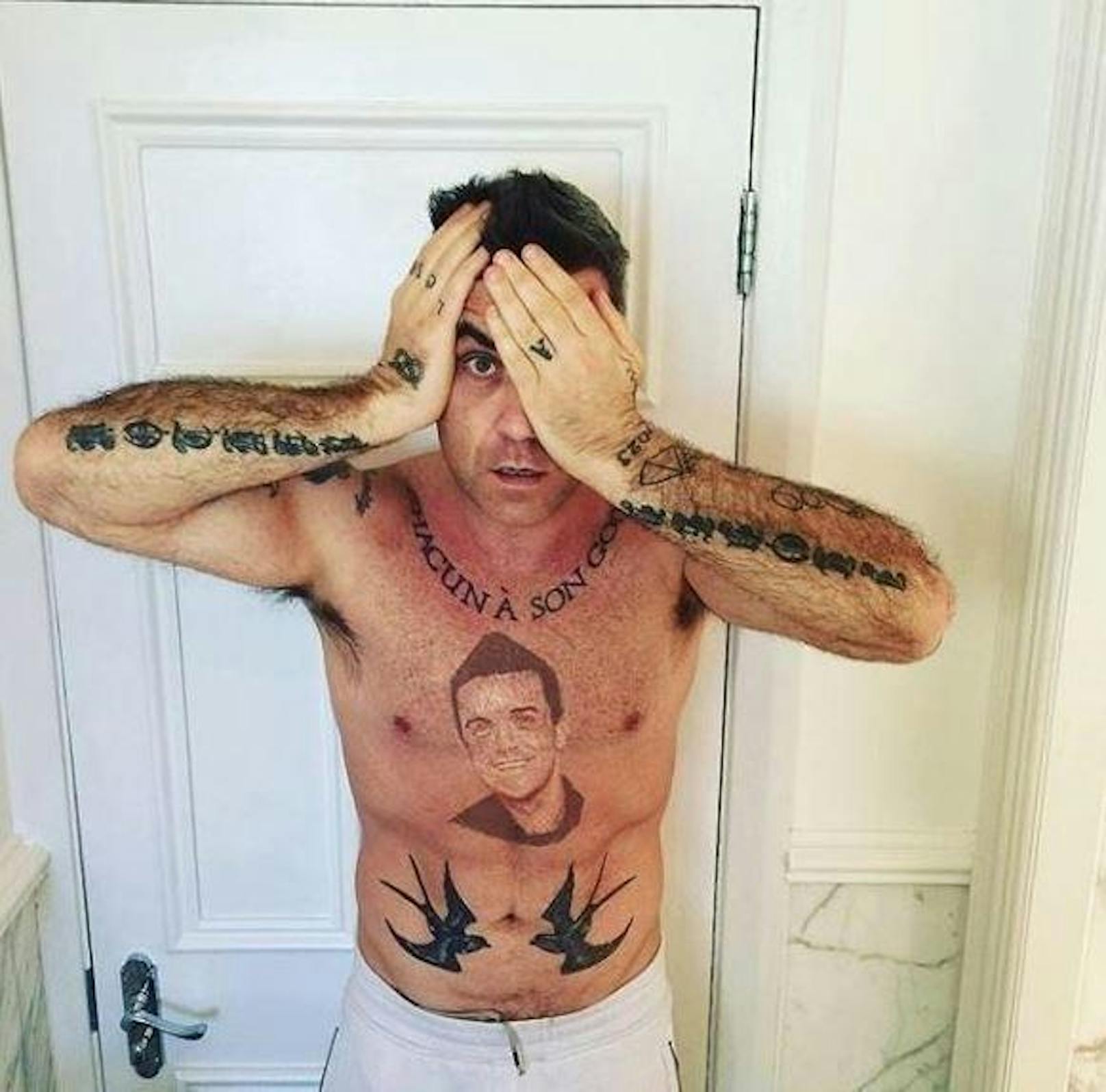 18.04.2018: Robbie Williams ließ sich auf die Brust ein Porträt von sich selbst tätowieren. Oder ist das nur Fake? Seine Fans sind sich nicht einig.