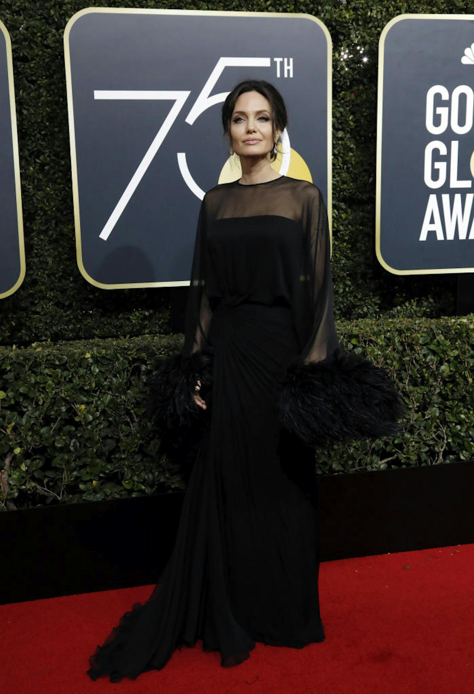 Auch Angelina Jolie hat in Schwarz schon größere Auftritte hingelegt, obwohl man zugeben muss, dass die Versace-Robe mit dem Feder-Detail äußerst elegant wirkt.