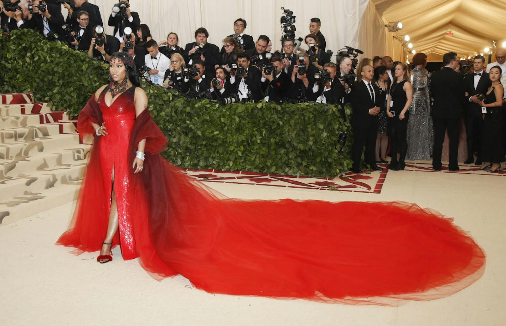 Rapperin Nicki Minaj kombinierte zu ihrem roten Oscar de la Renta Kleid mit Umhang einen Kopfschmuck aus Jet-Kristallen und einem kleinen roten Kreuz.
