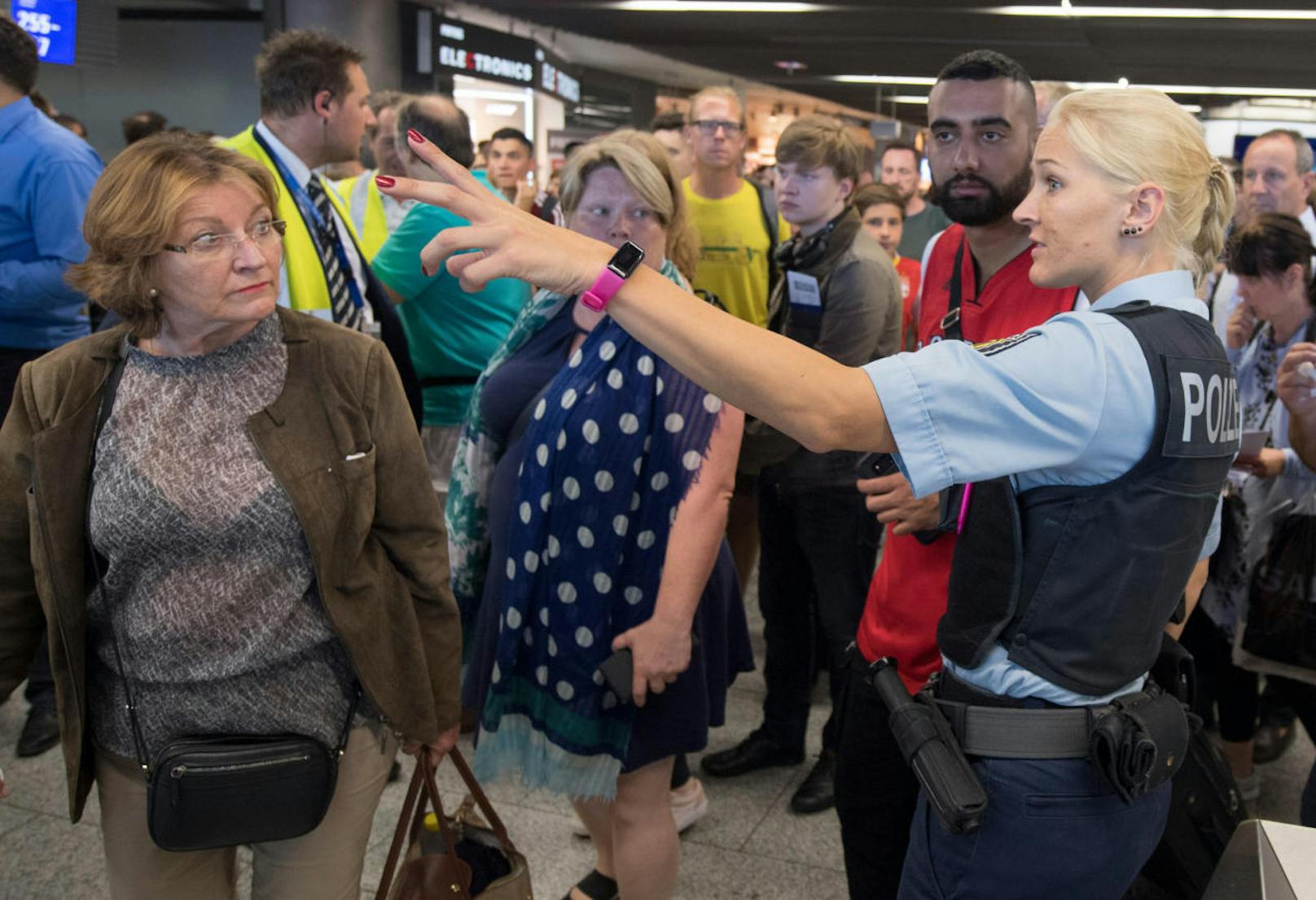 Polizisten und Passagiere stehen in Halle A im Terminal 1 des Flughafens Frankfurt. Am Flughafen läuft eine Teilräumung in einem der Abfertigungsgebäude. Grund dafür ist laut Bundespolizei ein Vorfall an der Sicherheitskontrolle, mindestens eine Person ist unberechtigt in den Sicherheitsbereich gelangt. 