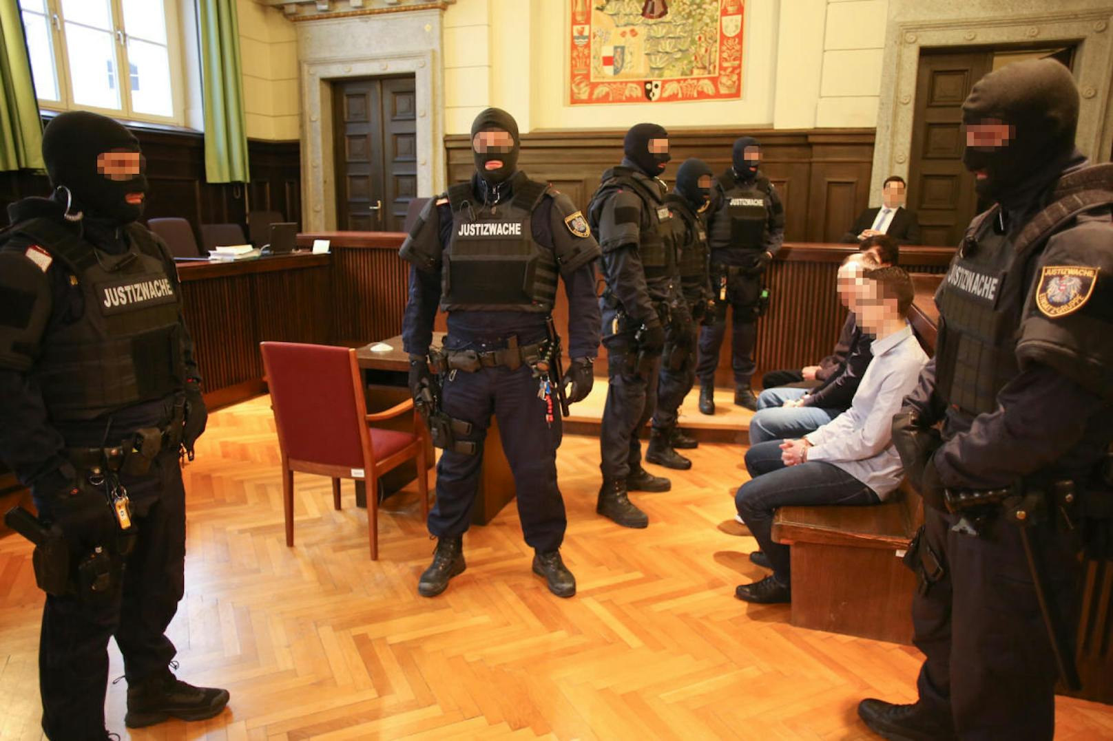 Die sieben Angeklagten wurden unter strenger Bewachung ins Gericht gebracht.