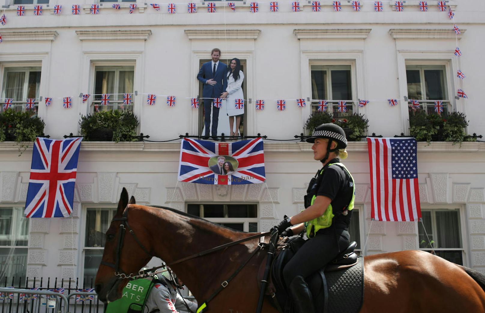Prinz Harry und Meghan Markle lächeln von einem Balkon in Windsor - die Pappkameraden halten bis zur Hochzeit die Stellung 