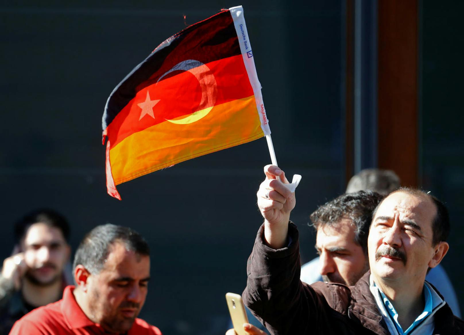 Ein Erdogan-Anhänger schwenkt eine deutsch-türkische Flagge.