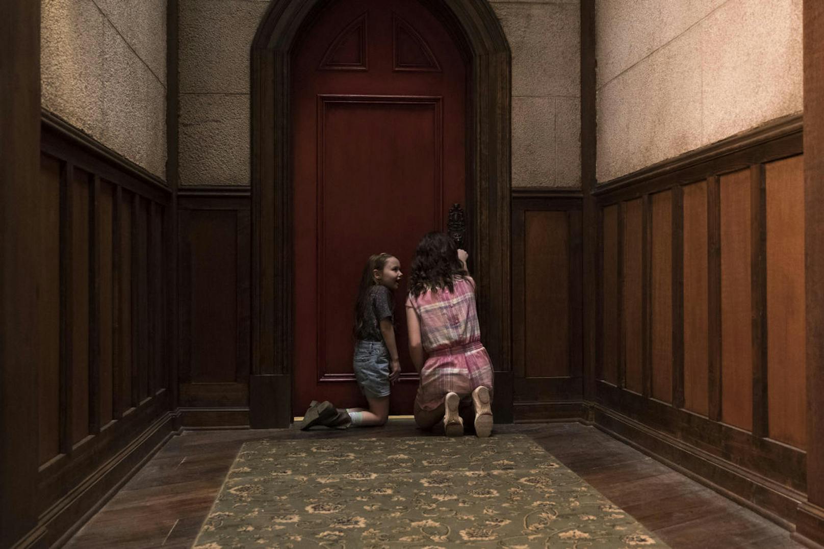 Nell (Violet McGraw) und ihre Schwester Shirley (Lulu Wilson) machen sich an der mysteriösen roten Tür von Hill House zu schaffen. 