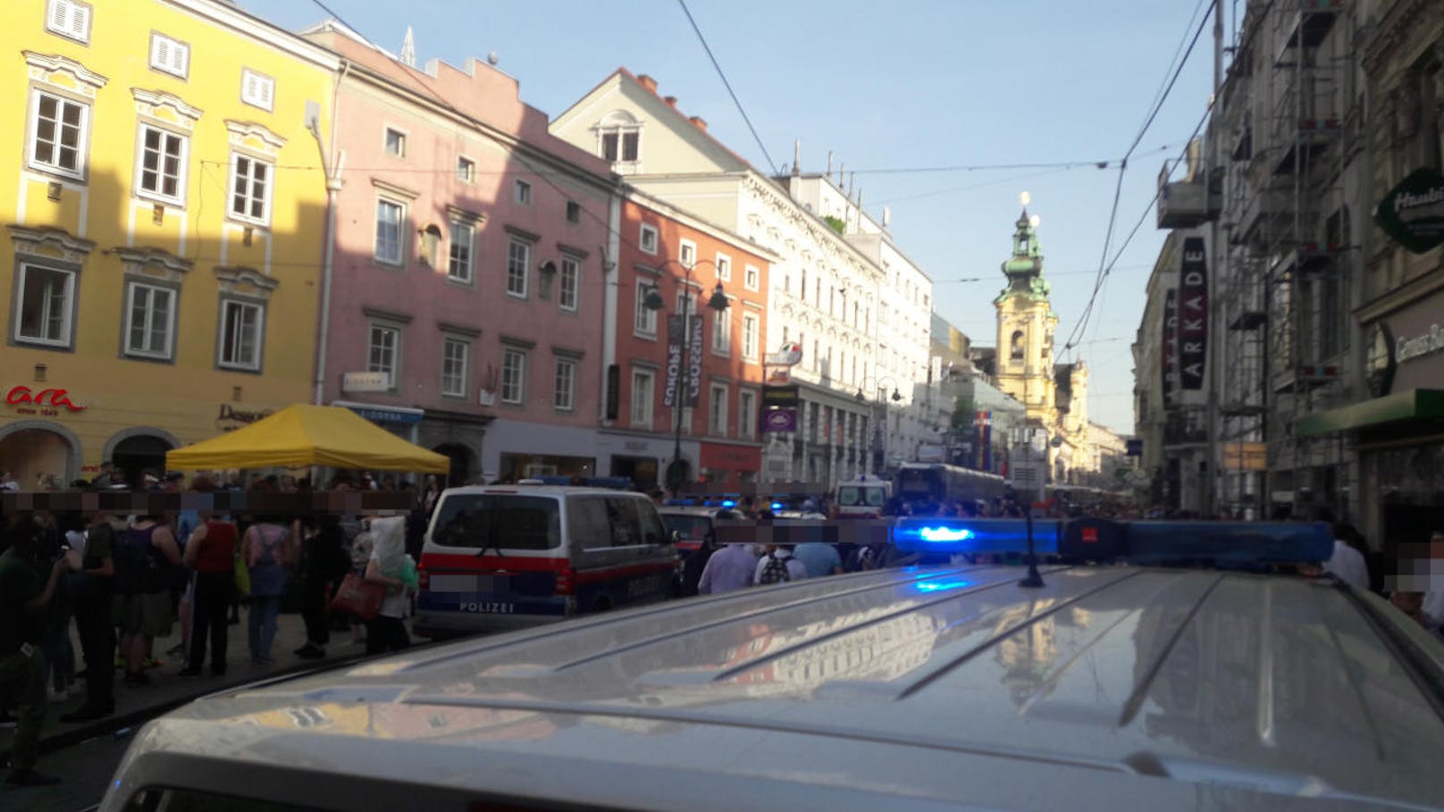 Großangelegter Polizeieinsatz in der Linzer City gegen 17:45 Uhr. Fünfzehn Polizeiautos sperren mit Blaulicht den Bereich rund um den Taubenmarkt ab.
