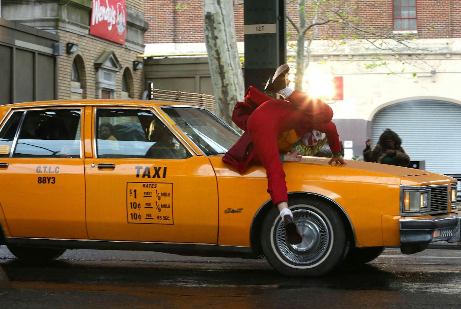 Ein Yellow Cab, New Yorks Taxi, rammt den Joker. Nach einem unsanften Stopp auf der Motorhaube ....